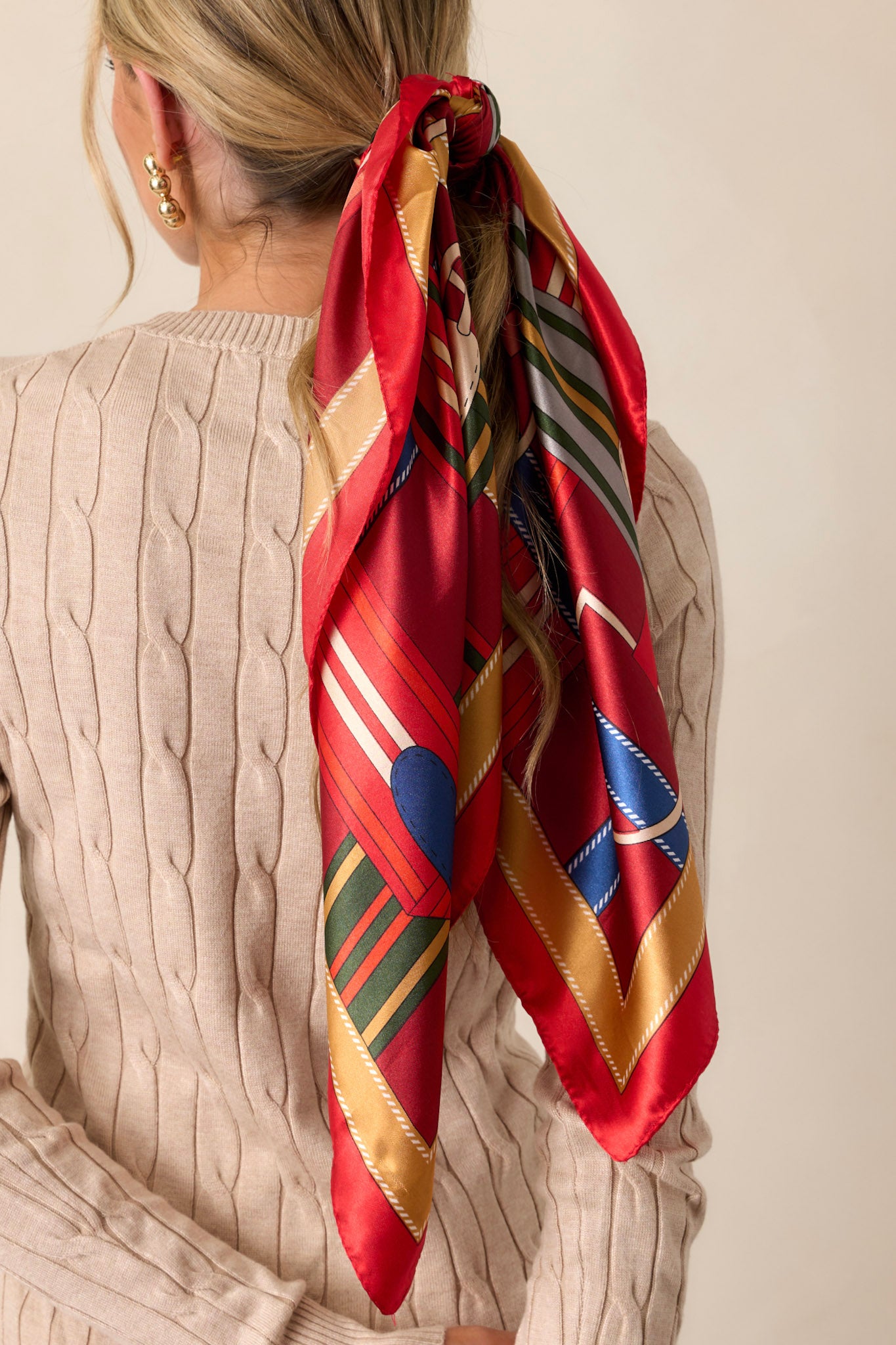 A detailed close-up of the red satin scarf, showing the fine weave and clarity of the multicolored print.