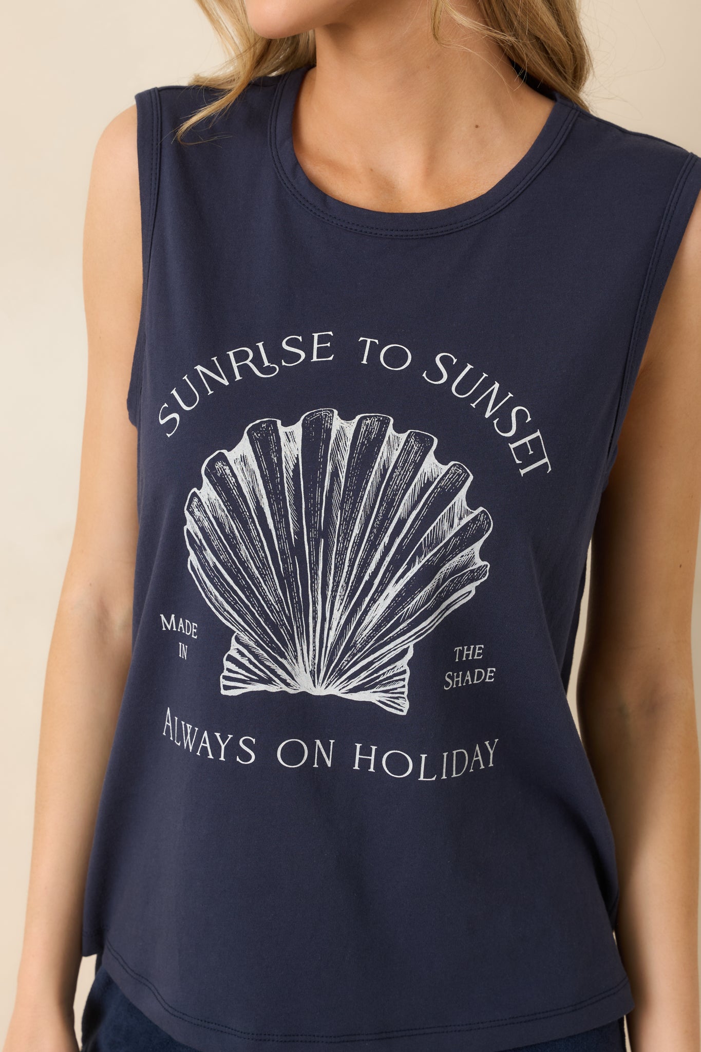 Close-up of vintage-style shell graphic with “Sunrise to Sunset” text on soft fabric.