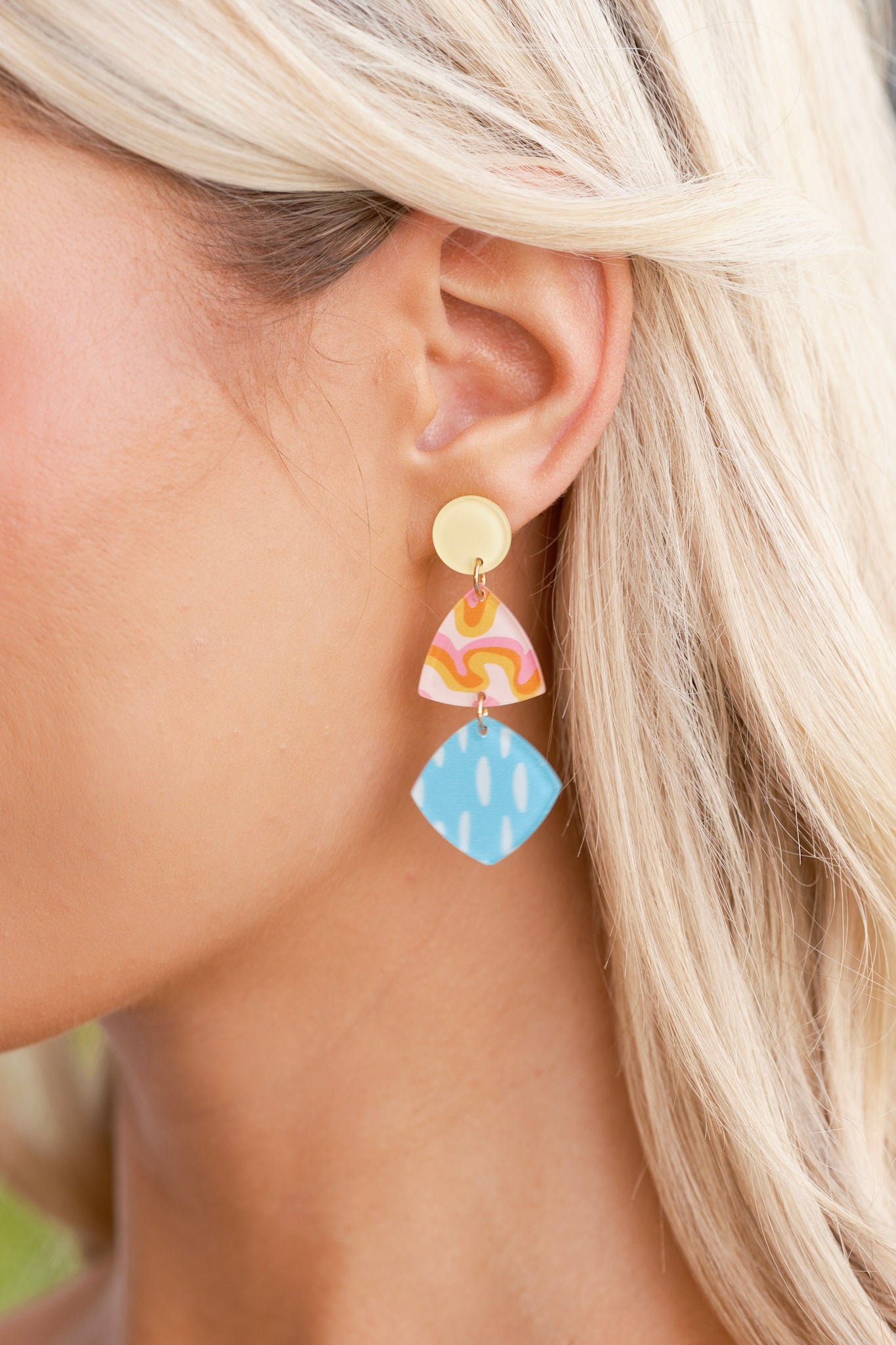Close-up view of the earrings highlighting the yellow acrylic circular stud and gold hardware connecting the geometric acrylic shapes below.