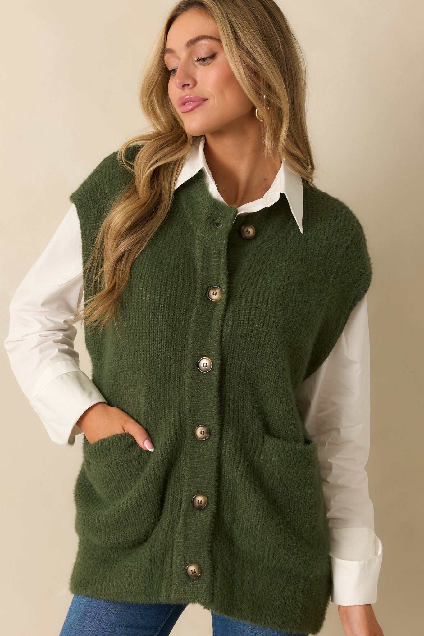 Close view of the button-front detail and knit texture of the green cardigan.