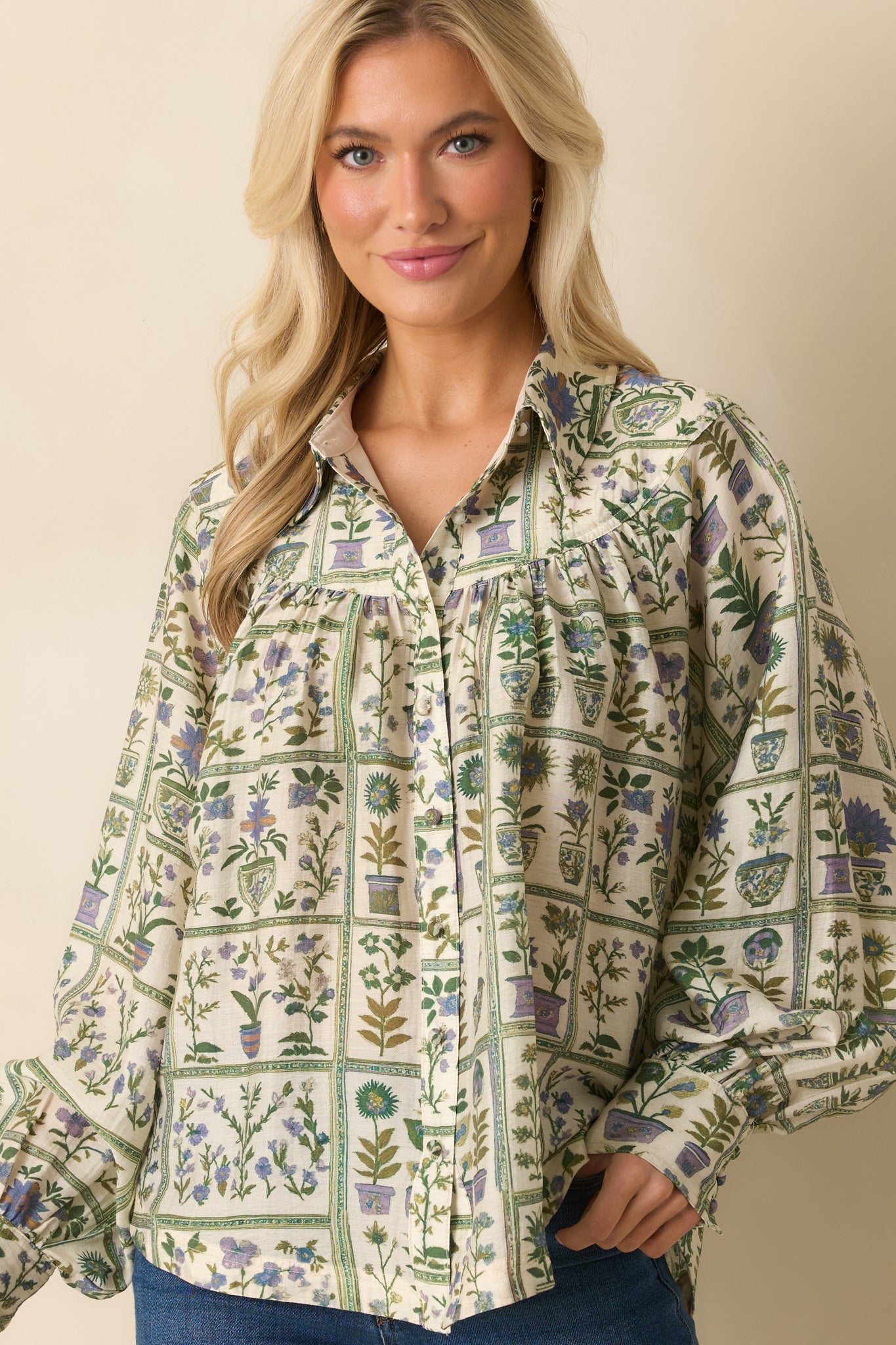 Close view of the collared neckline and top buttons of the green floral blouse.
