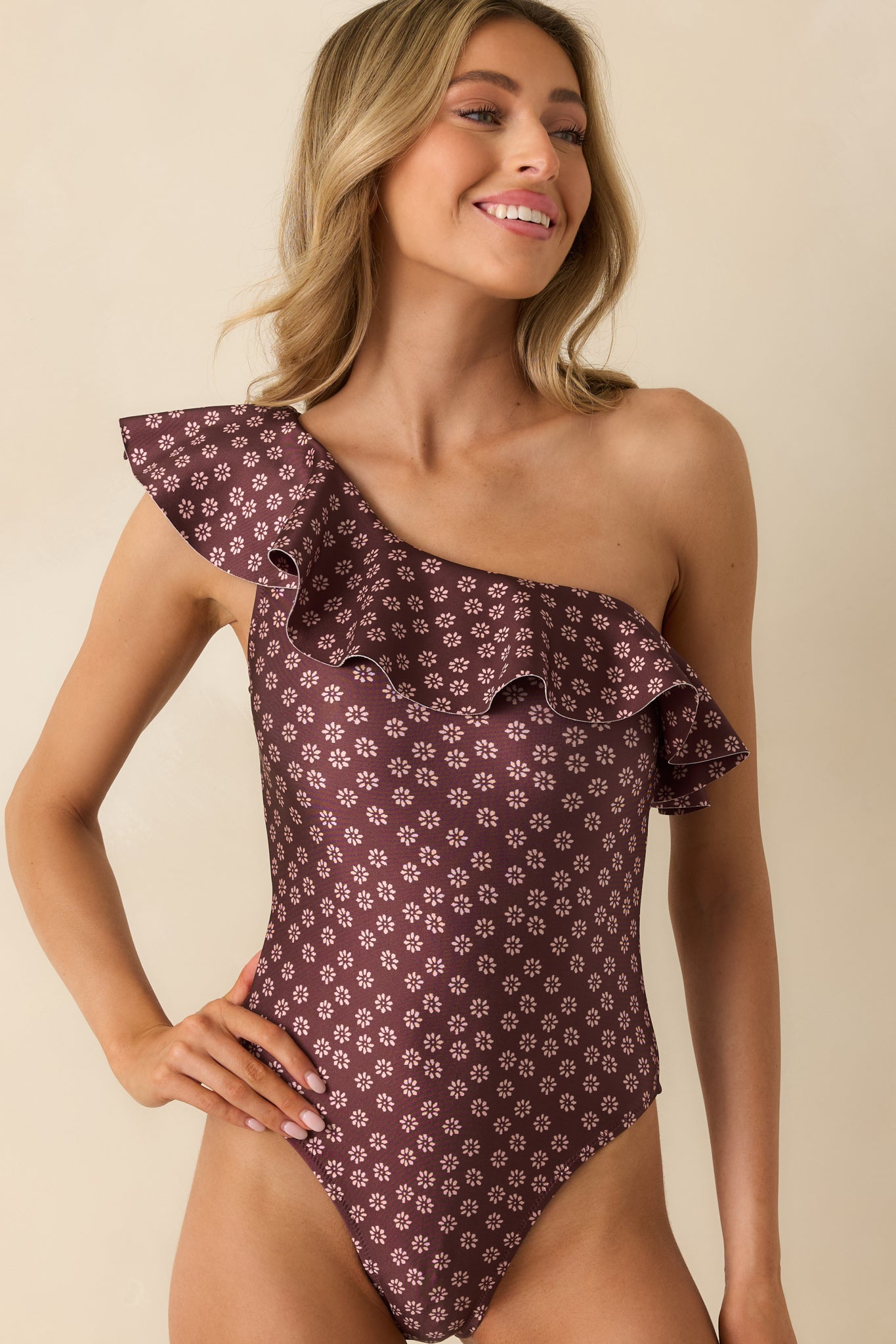 Close view of the floral ruffle neckline on the burgundy one-shoulder swimsuit.