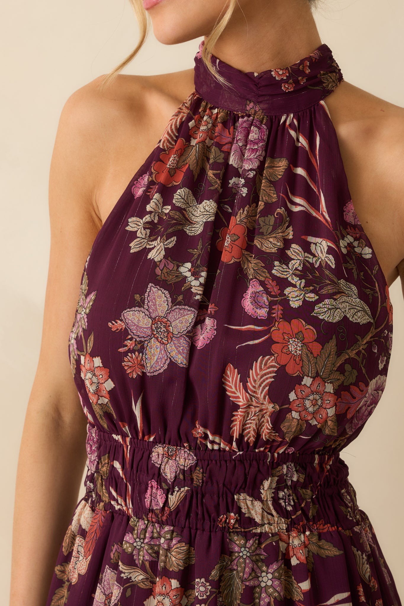 A close view reveals the gathered halter neckline, lightweight semi-sheer fabric, and multi floral print.