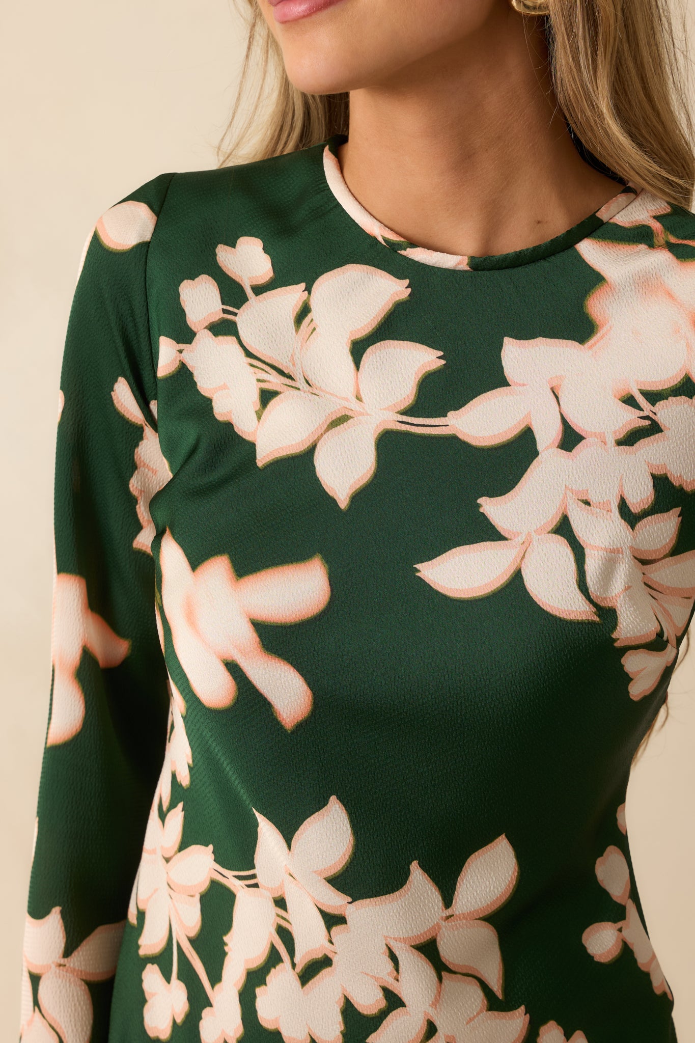 A close view reveals the hammered satin texture, floral print, and fine stitching along the neckline and bodice.