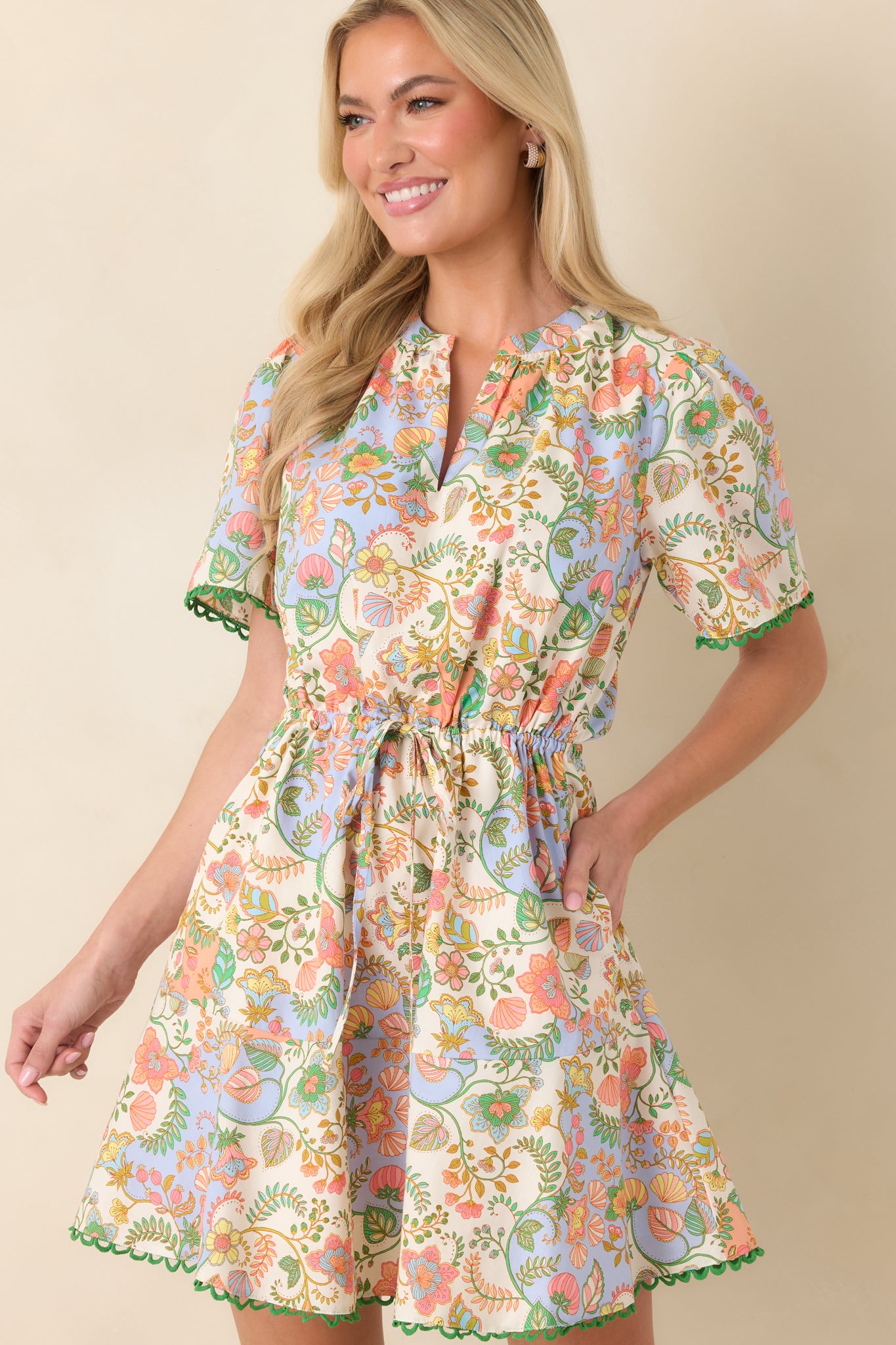 Close view highlighting the split neckline and short sleeves with contrasting green scallop trim.