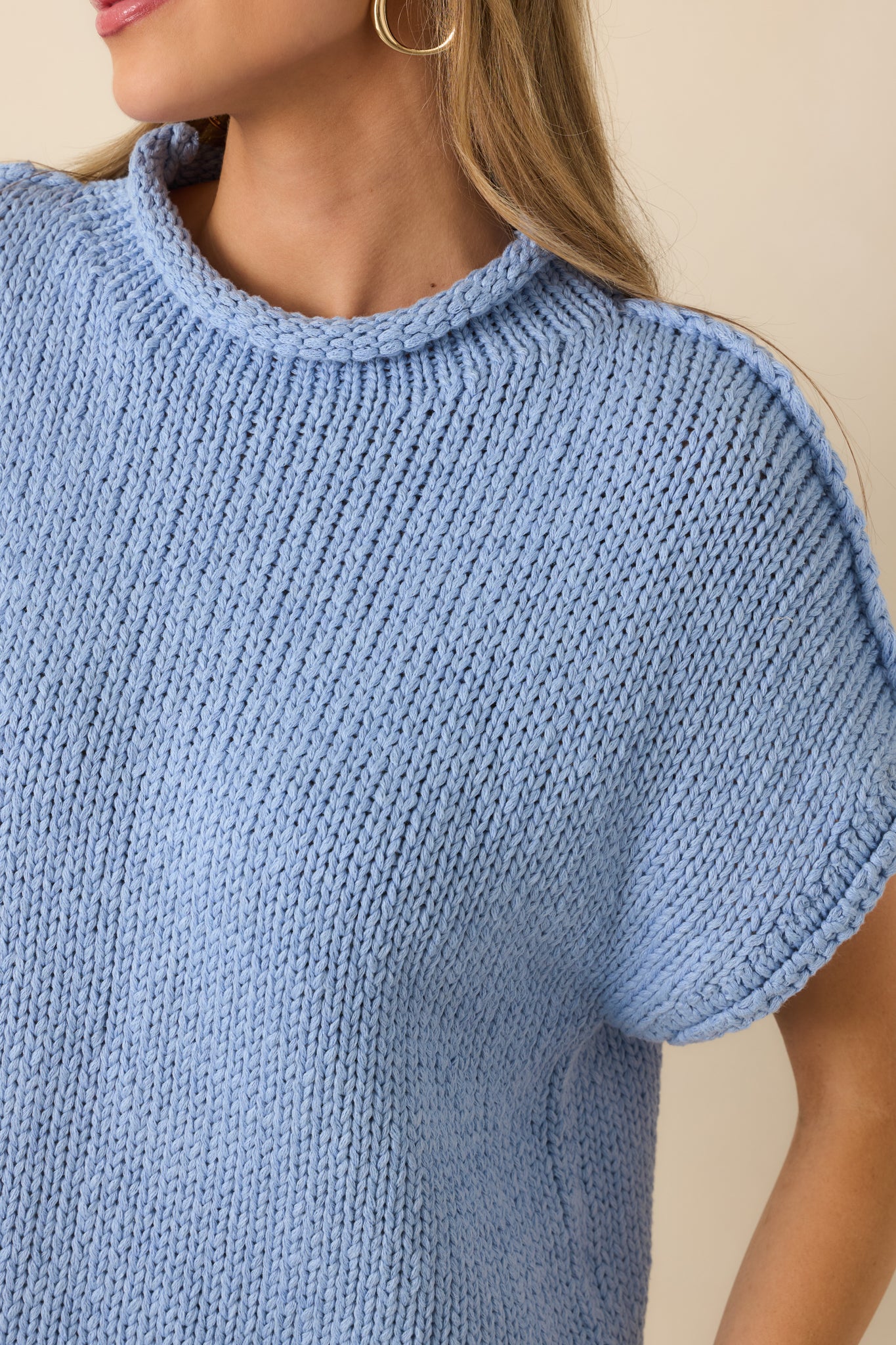 Ultra close view of chunky knit fabric in light blue, thick yarn weave and depth of stitch.