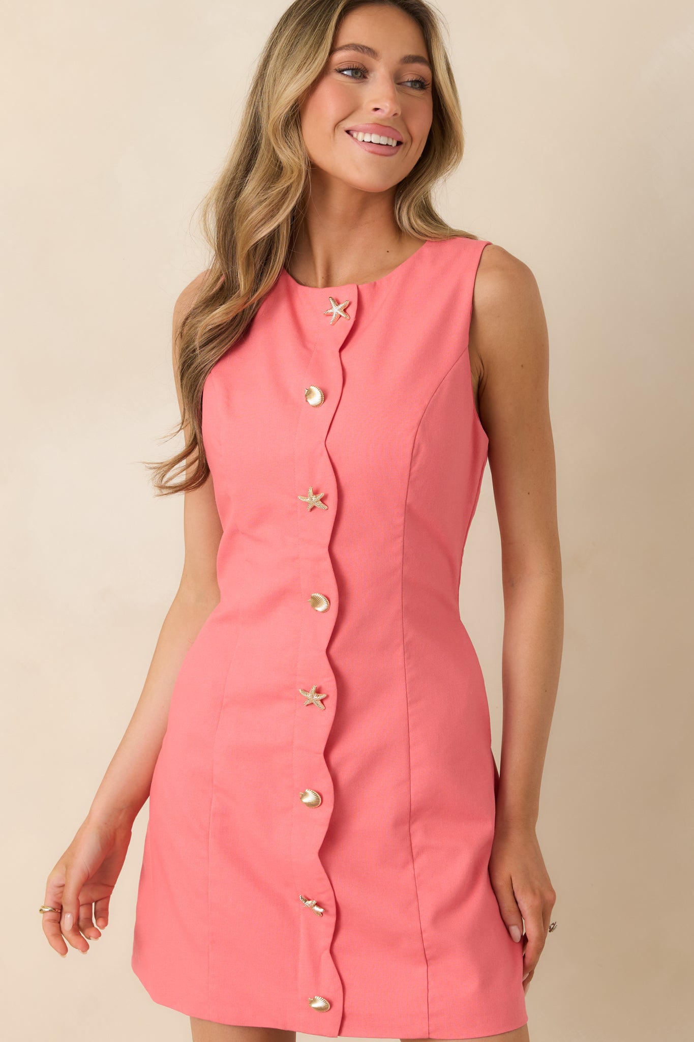 Close view of coral dress with structured shape and decorative shell buttons