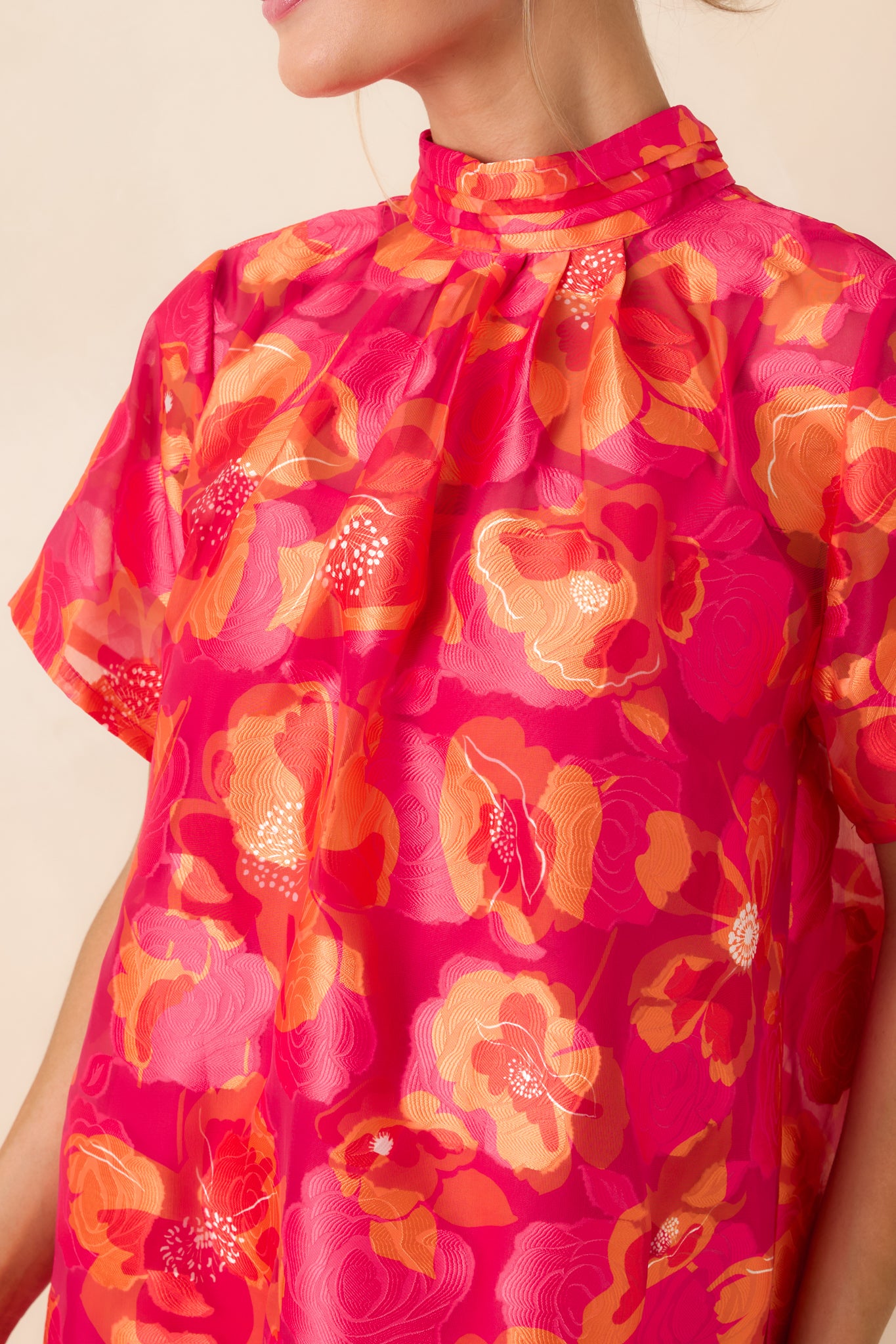 Close view of tiered ruffle hem, gathered bodice, and soft draping on lightweight mini dress.