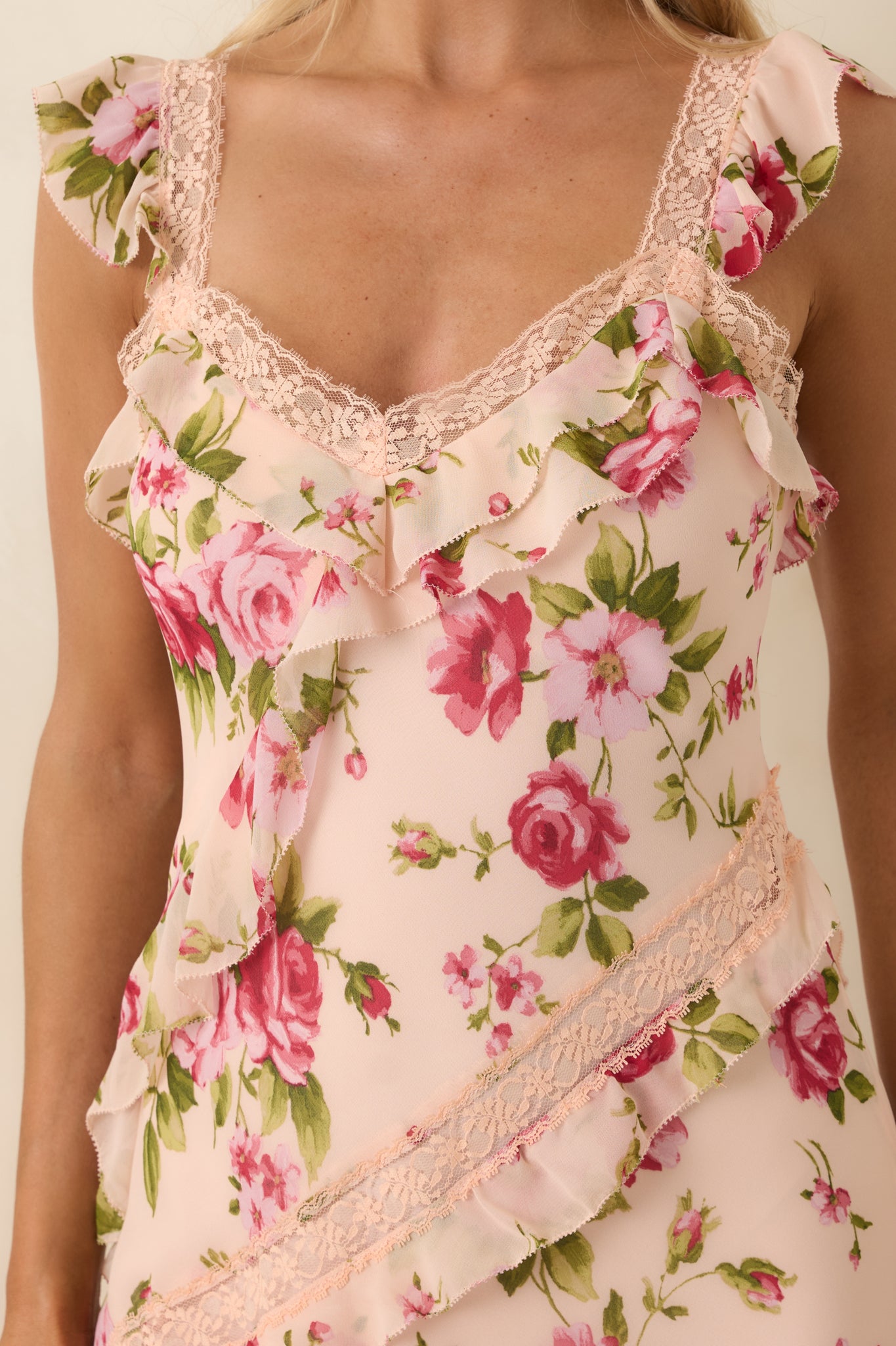 Close view of lace-trimmed neckline with intricate detailing and soft cascading ruffle layers.