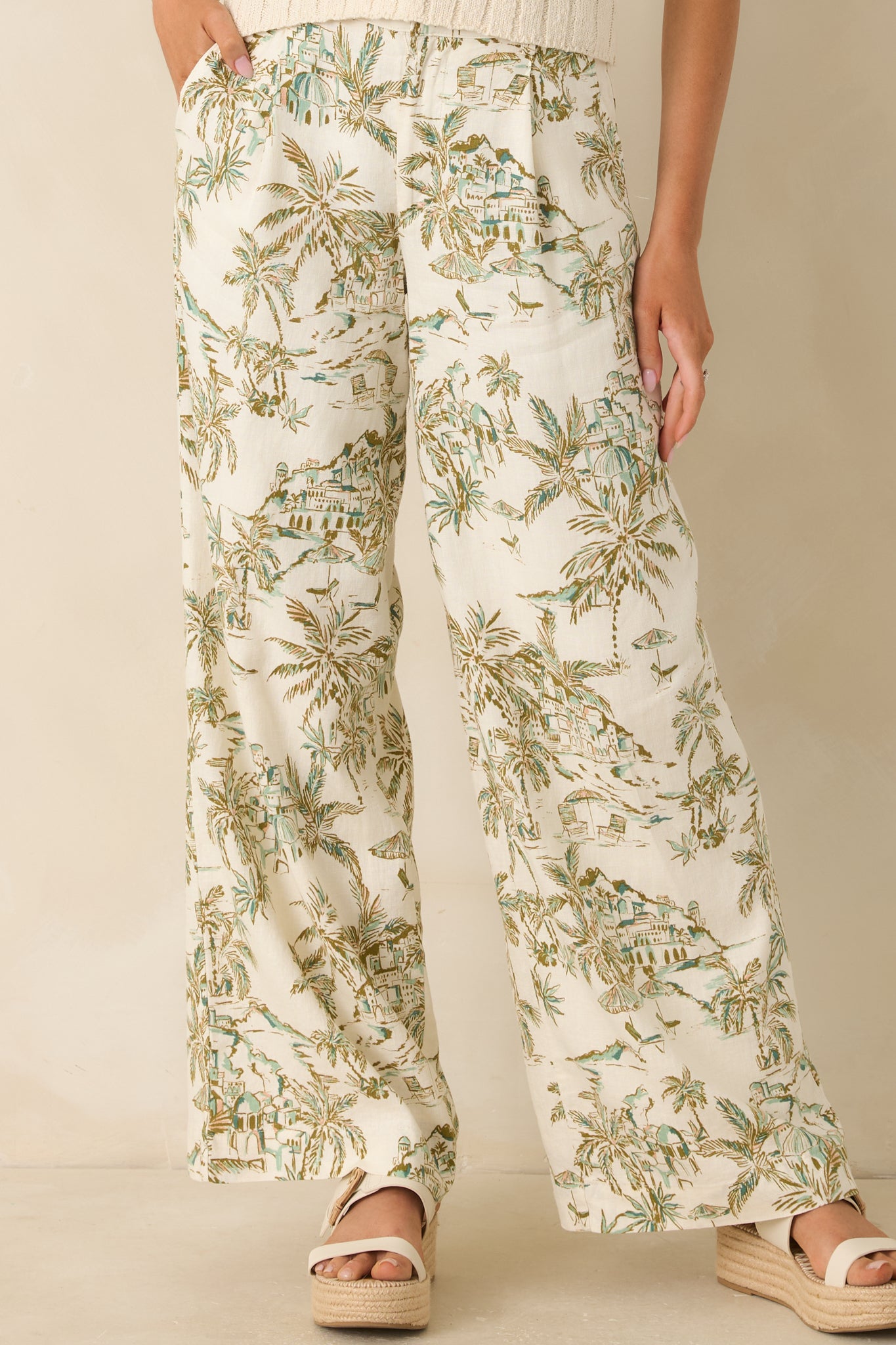 Close view of the high-rise waistband highlighting the button-front closure detail on the tropical print pants.