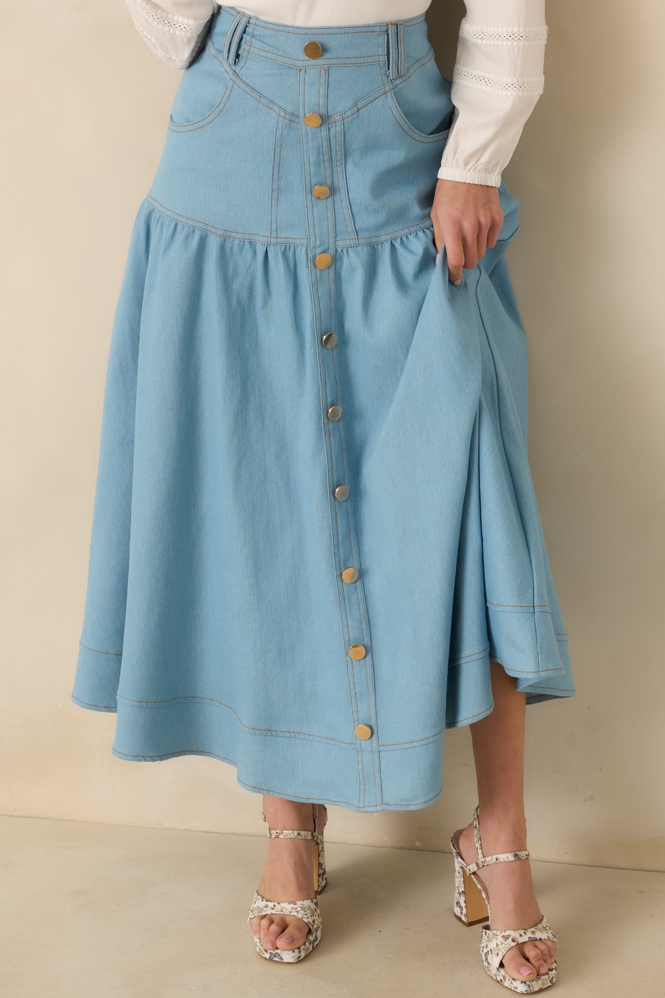 Close view of the high-rise waistband with belt loops and gold-tone button front detail.