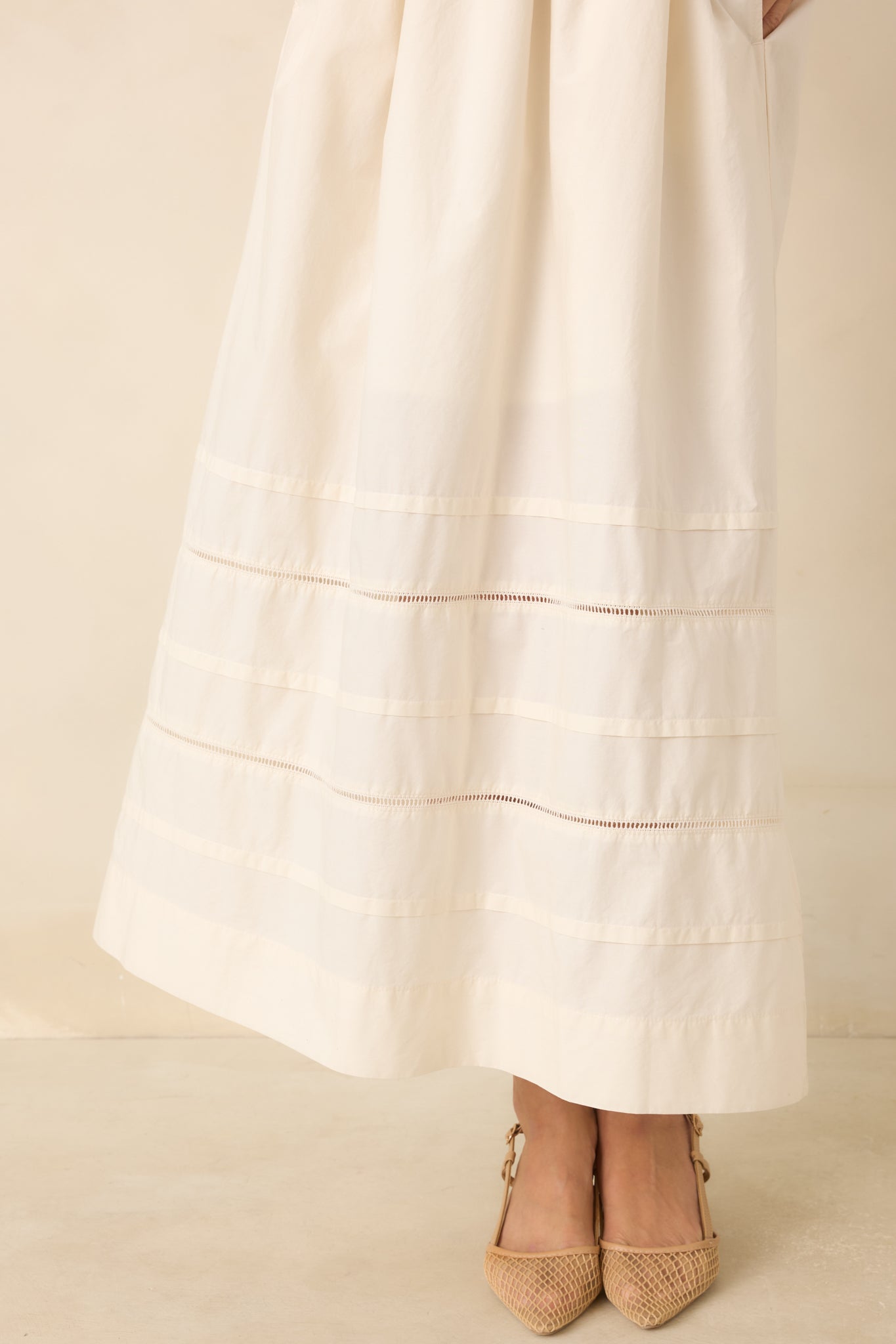 Close view of the gathered cotton poplin skirt with subtle horizontal inset panels near the hem add texture and dimension to this timeless design.