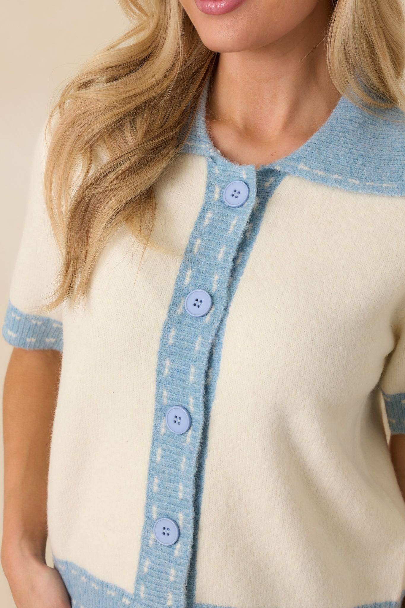 Close view of the lightweight knit blend showcasing the ivory base with clean light blue contrast trim.