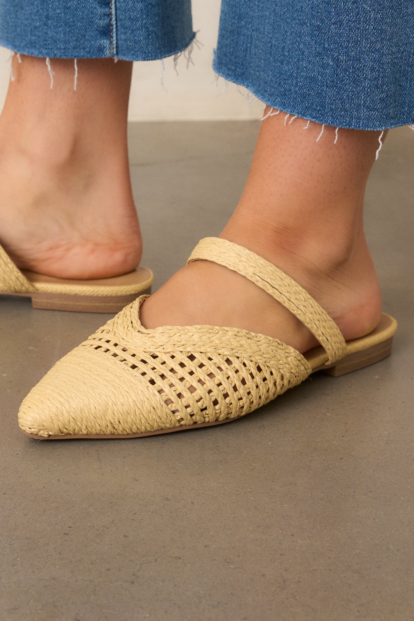 A closer look at the intricate woven raffia design, showing the lightweight texture and clean lines of the pointed-toe flats.