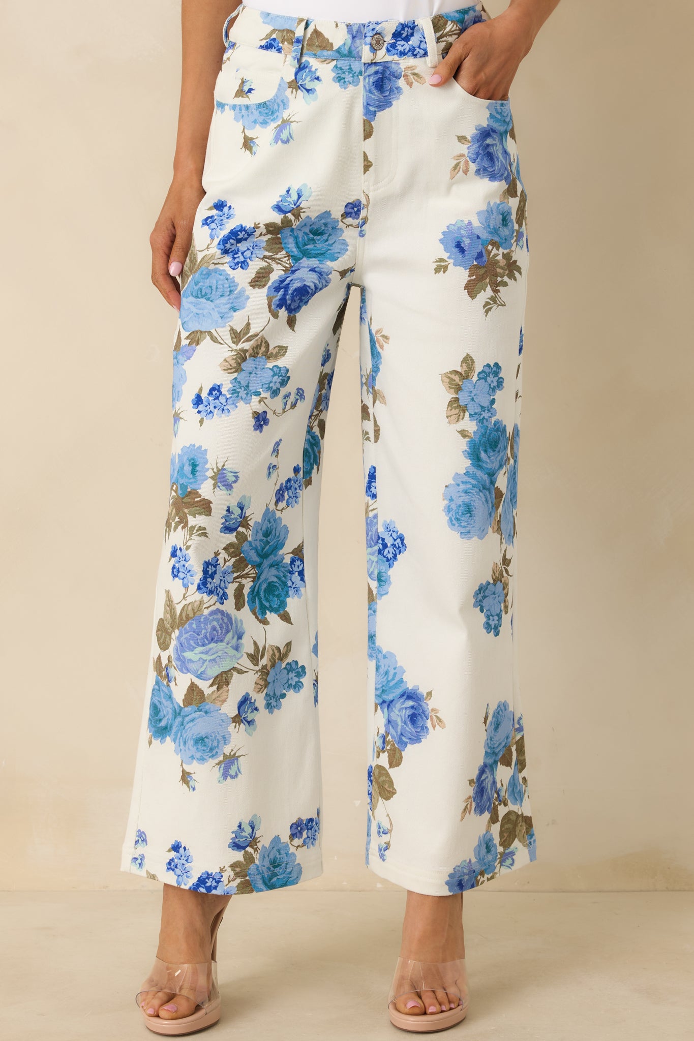 Closer view of the high-rise waistband, front button closure, and wide-leg shape in floral cotton.