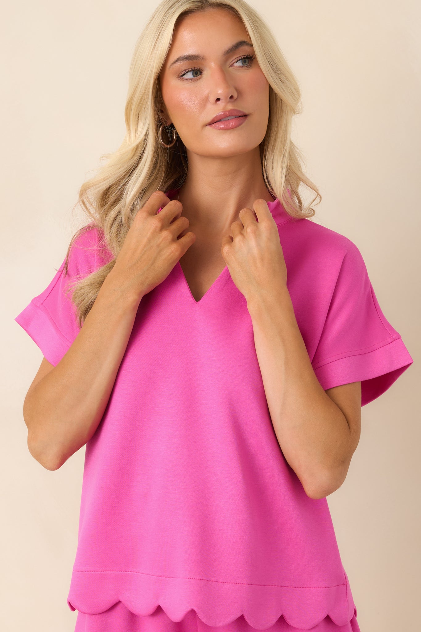 Closer view of the scalloped edge detailing and comfortable relaxed fit of the vibrant pink top.