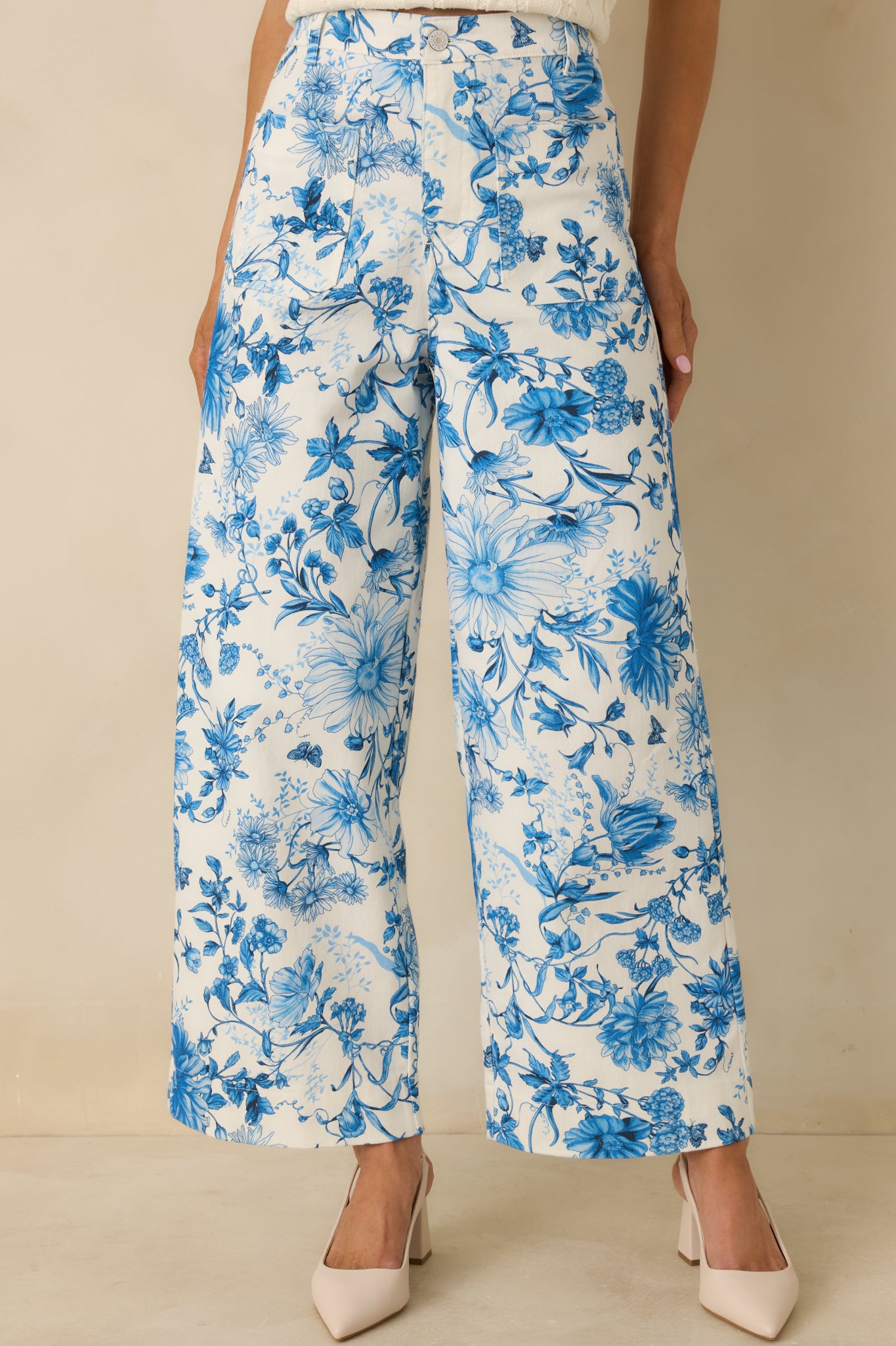 Closer view showing belt loops and functional front patch pockets on the floral pants.