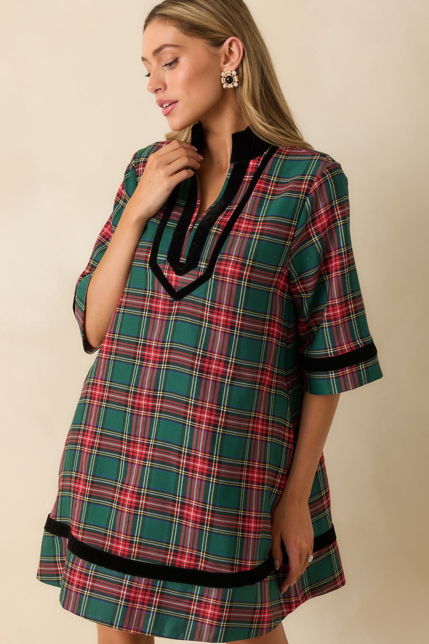 Crop highlighting side pocket, fabric texture, and subtle black velvet trim on the green plaid dress