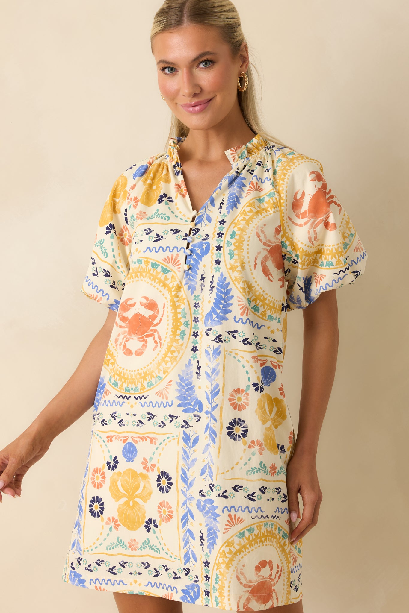 Close-up of the cotton mini dress emphasizing the detailed shell, crab, floral, and Mediterranean-inspired patchwork print.
