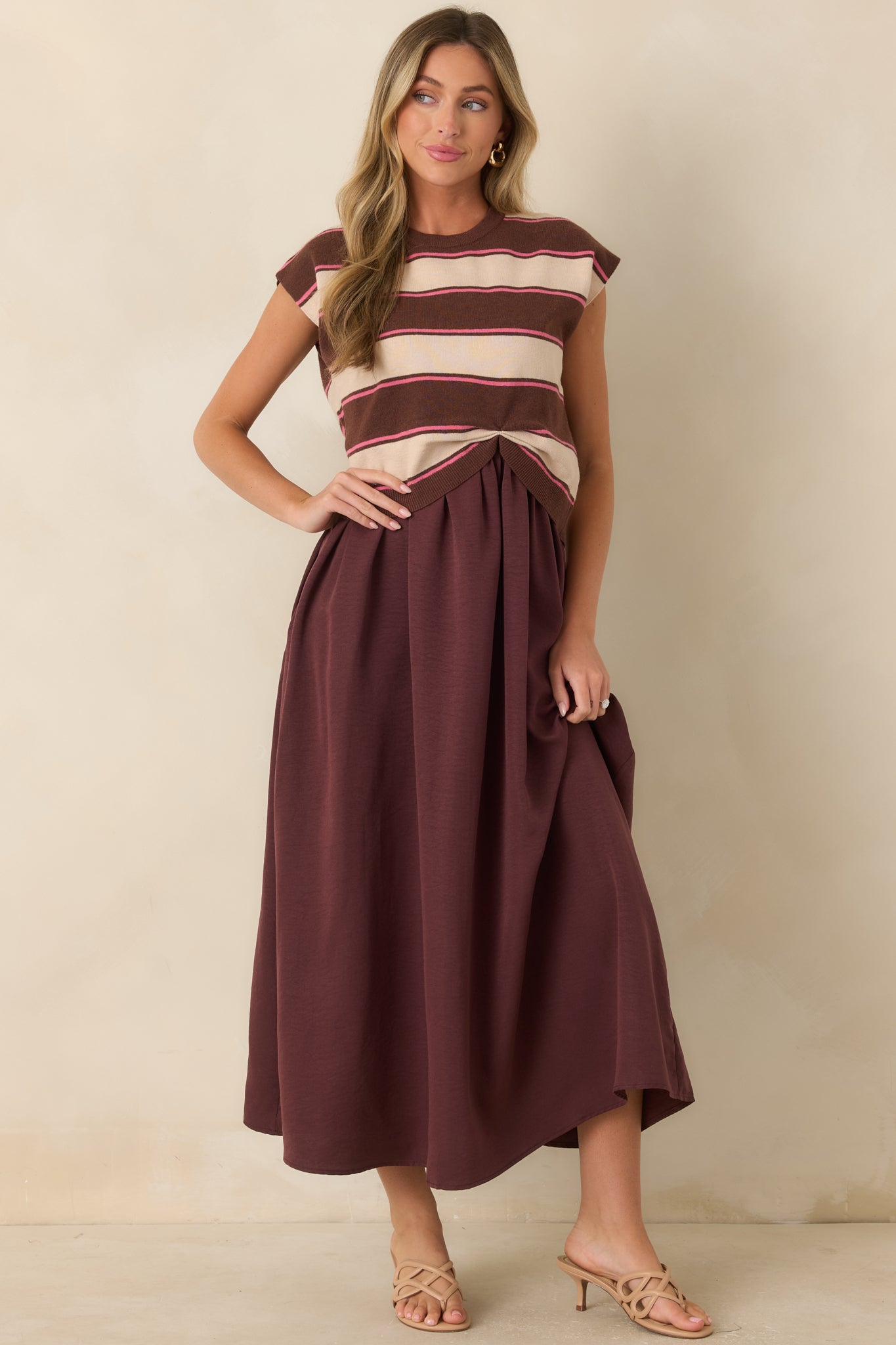 Cocoa-toned maxi dress designed with cream and subtle pink stripes, a knit-inspired overlay, and an elegant full-length silhouette.