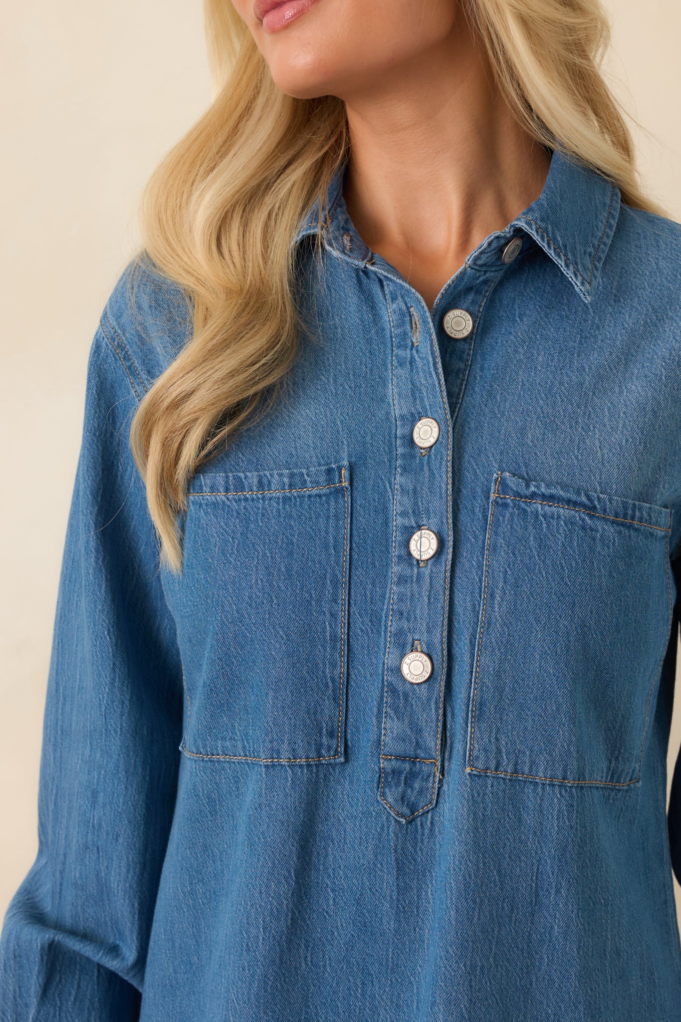 Close-up detail of the collar, button placket, chest pockets, and cuff accents on the dress.