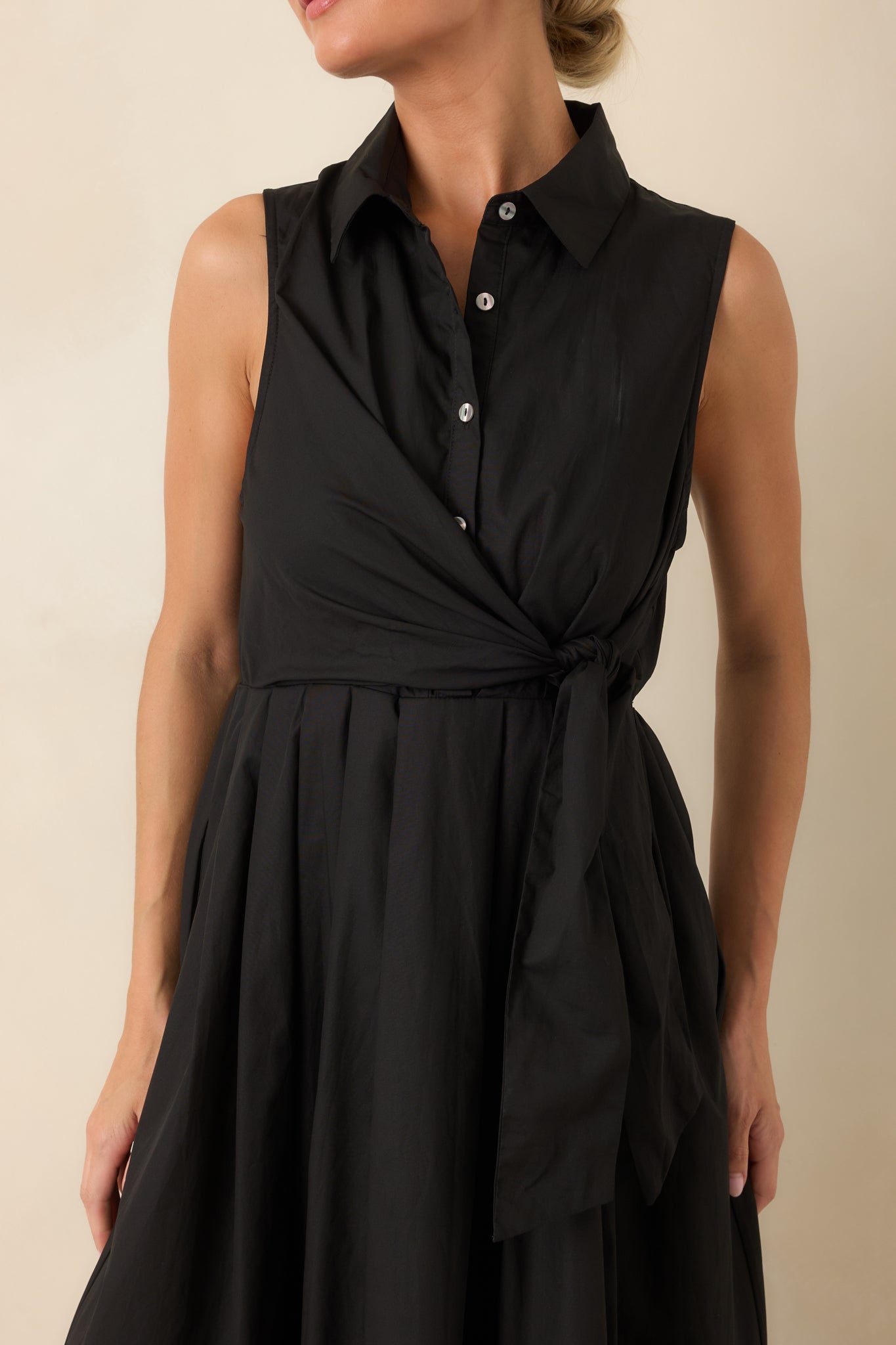 Close-up detail of the collared neckline, button-front bodice, and waist tie on the dress