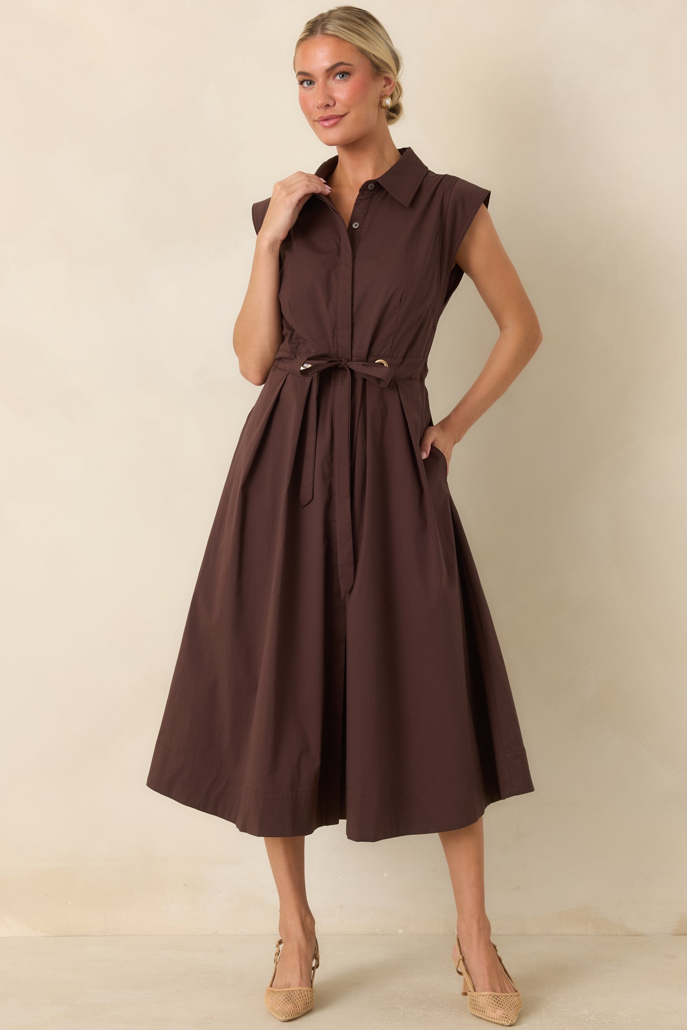 Collared cotton dress designed with cap sleeves, gold-tone belt details, and elegant movement.