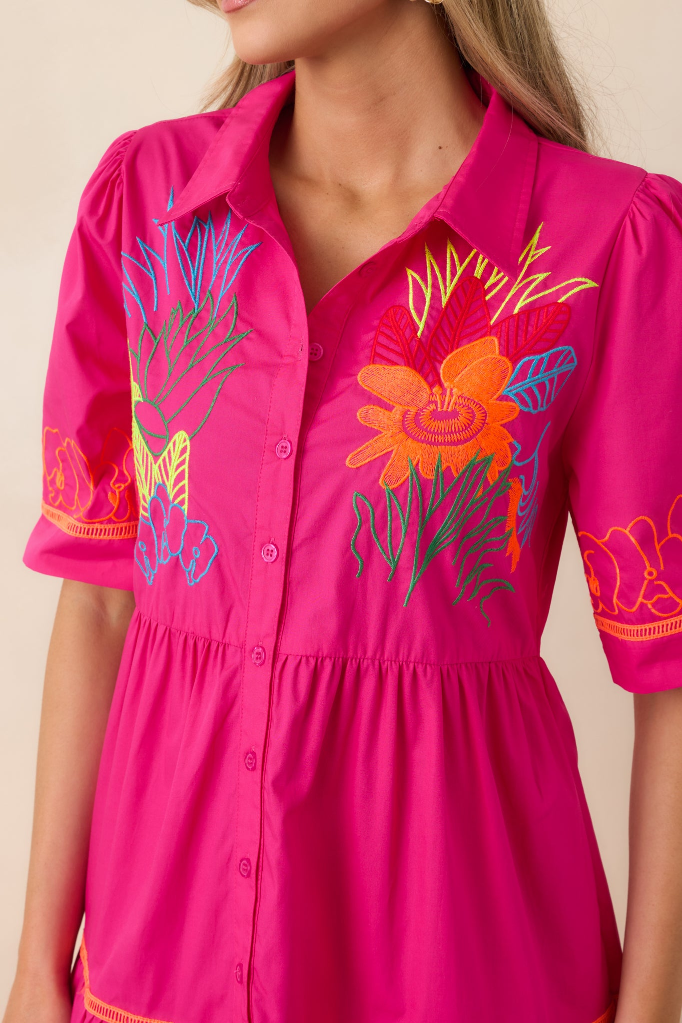 Collared neckline and button-front detail on colorful tiered fabric.
