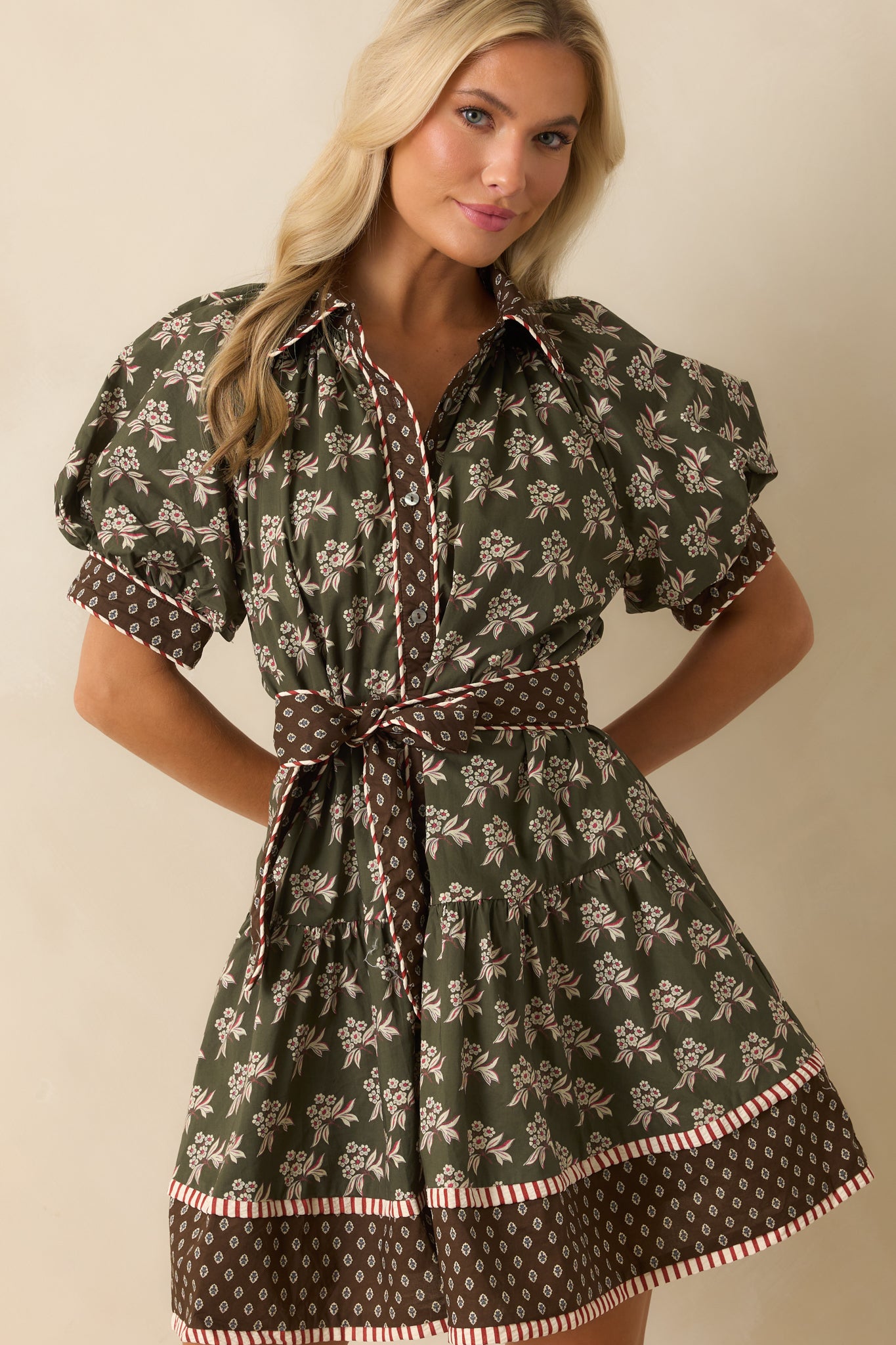 Collared neckline and functional button front highlighted with brown and ivory trim.