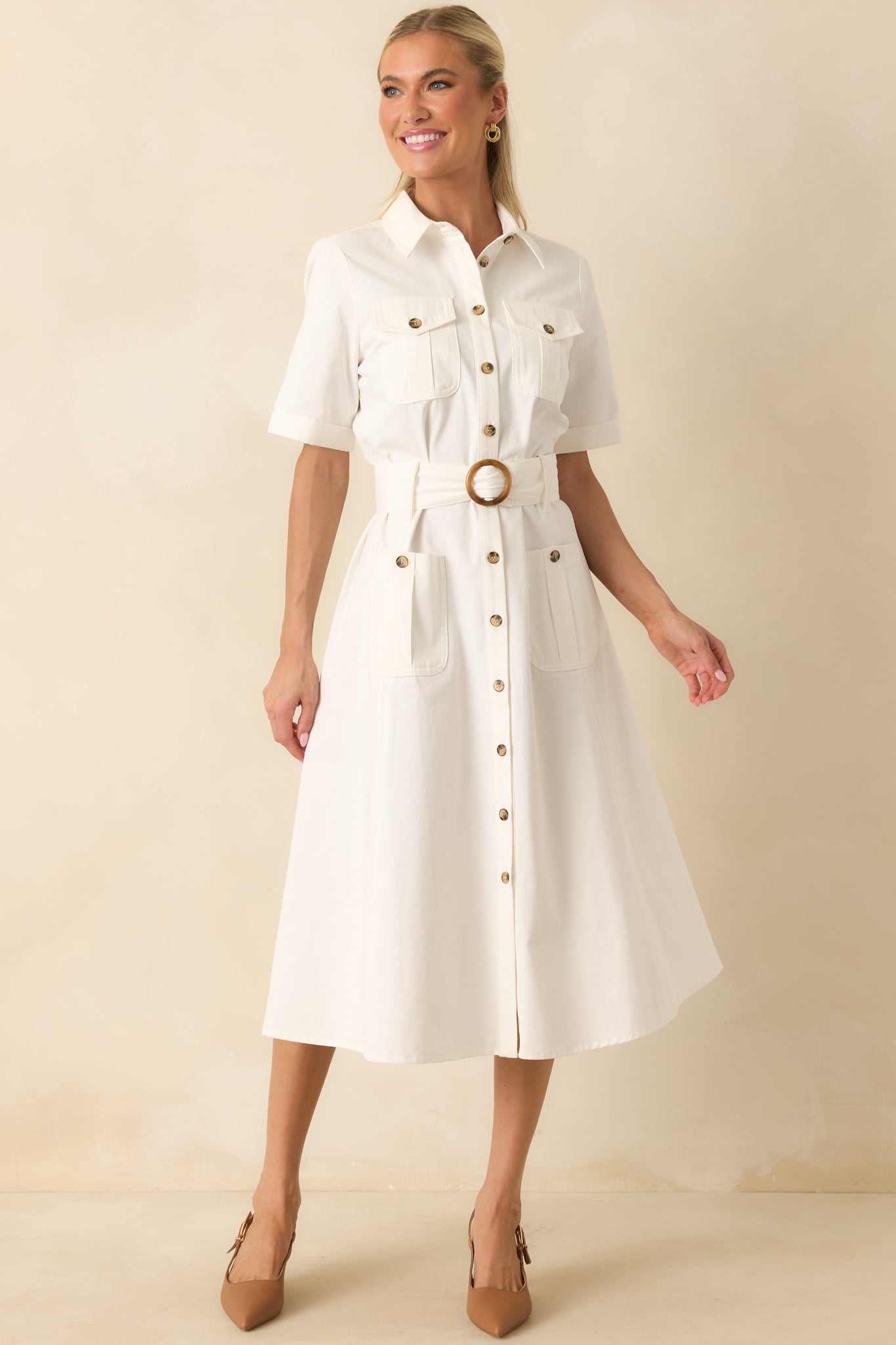 Collared midi dress with a fit-and-flare shape, utility-style pockets, cuffed sleeves, and a belted waistline.