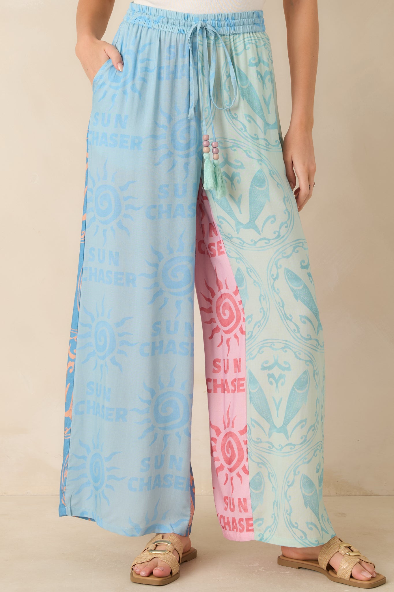 Close view of colorblock pants highlighting the sun motifs, bold patterns, and comfortable elastic waistband.