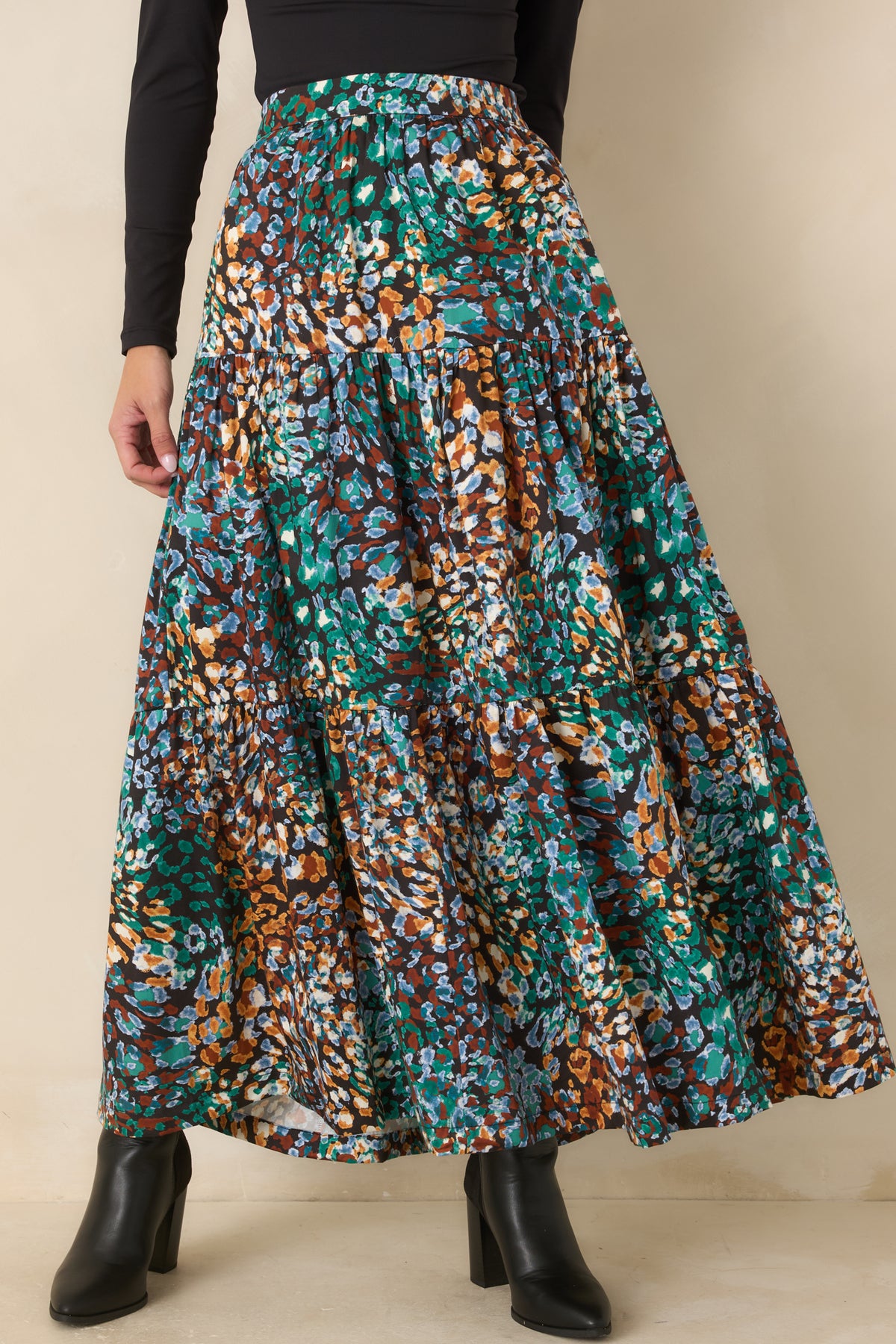 Colorful printed skirt showcasing the rich green, blue, rust, and ivory pattern on black.
