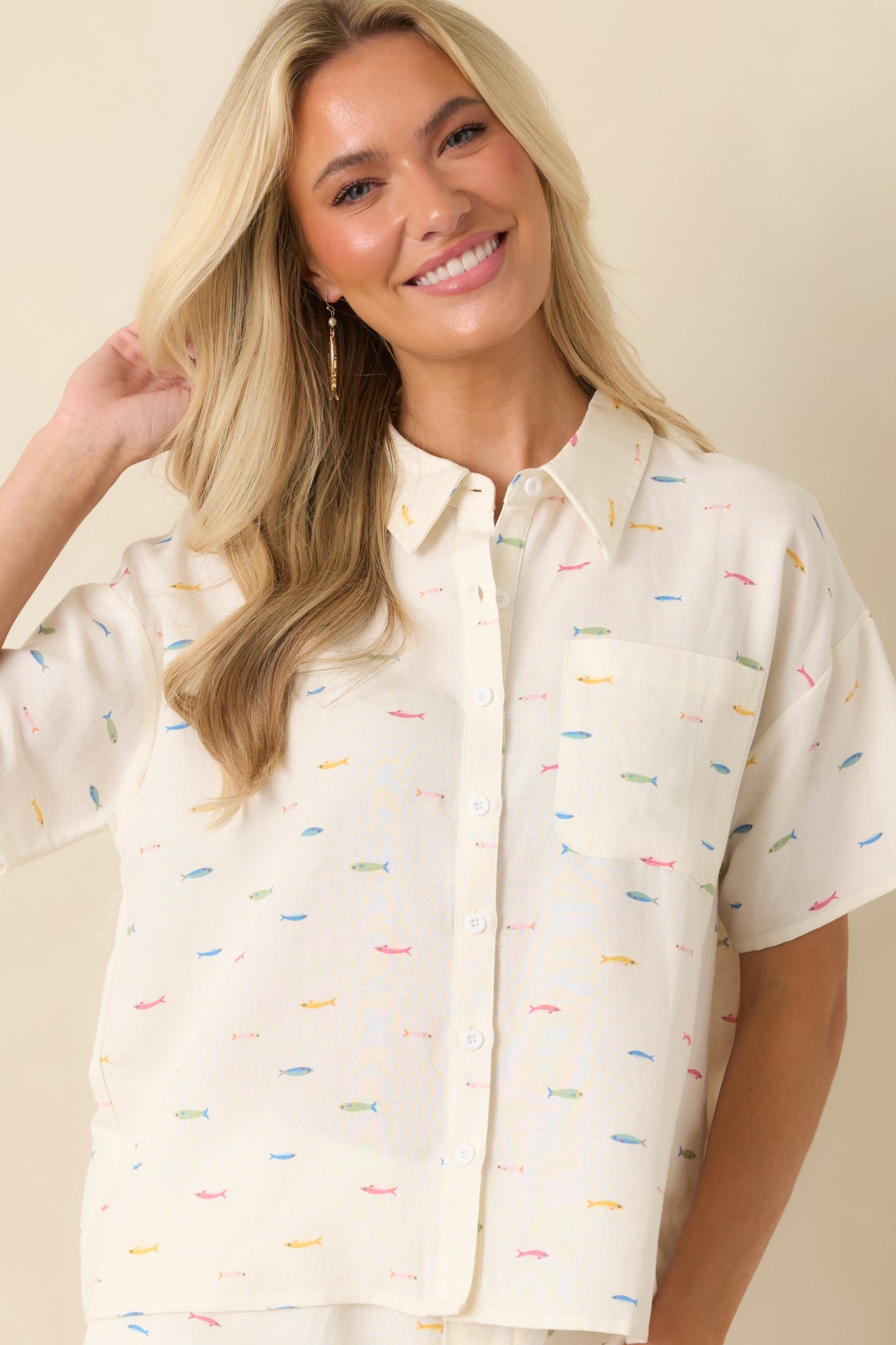 Detailed view of the colorful fish print scattered across the ivory cotton-linen blend fabric.
