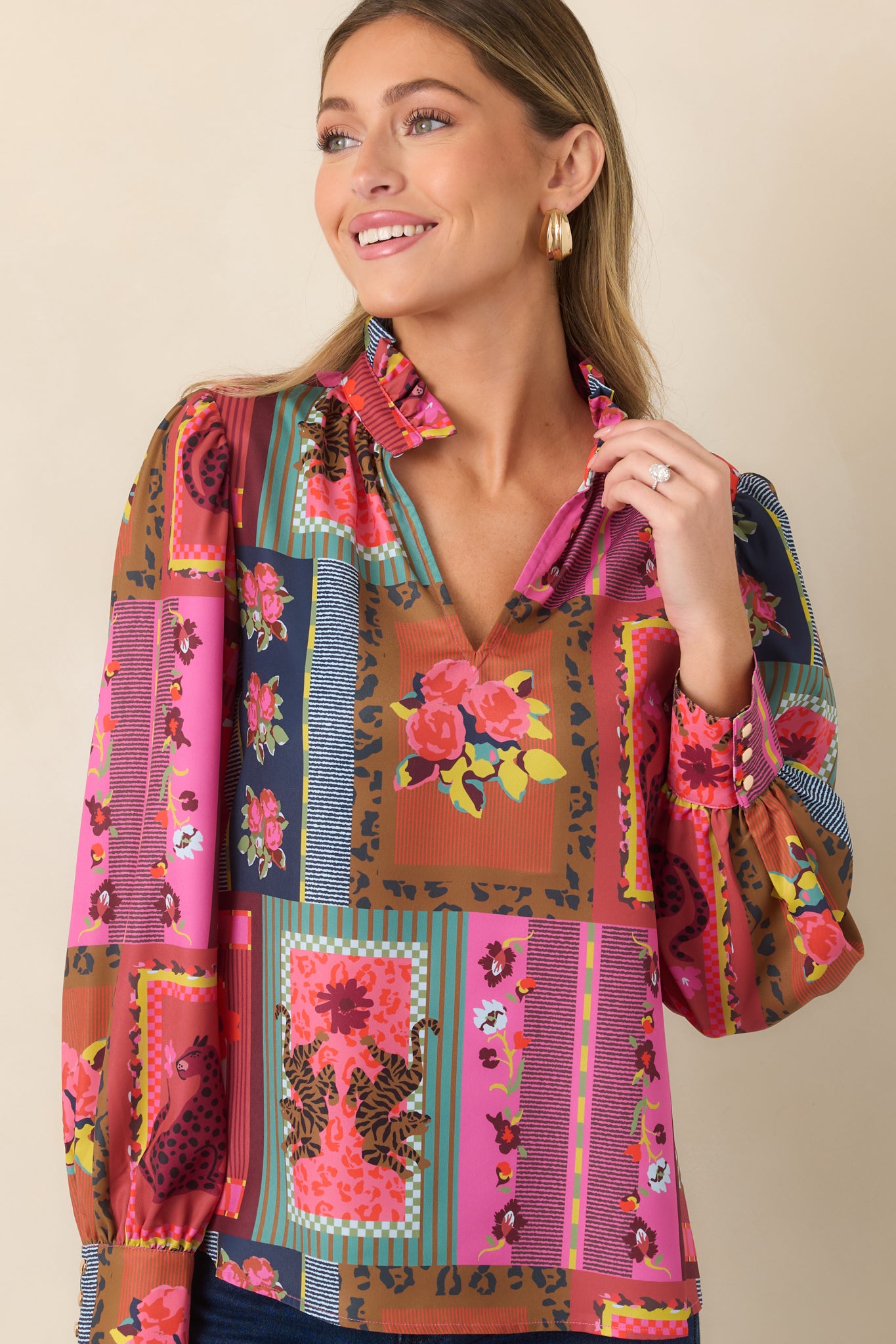 Colorful blouse detail featuring the ruffled neckline, subtle fabric sheen, and eclectic arrangement of florals, stripes, and framed motifs.