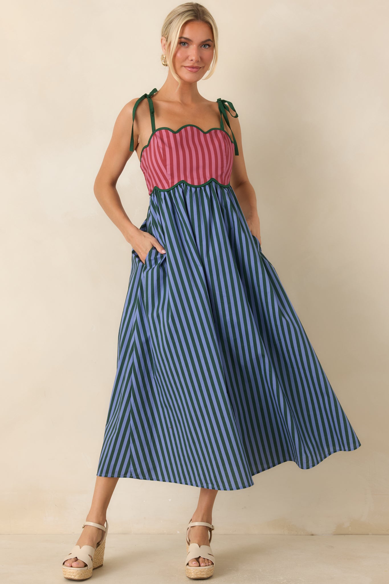Cotton midi dress with a colorful striped pattern, scalloped bodice, adjustable tie straps, and a flowing gathered skirt.