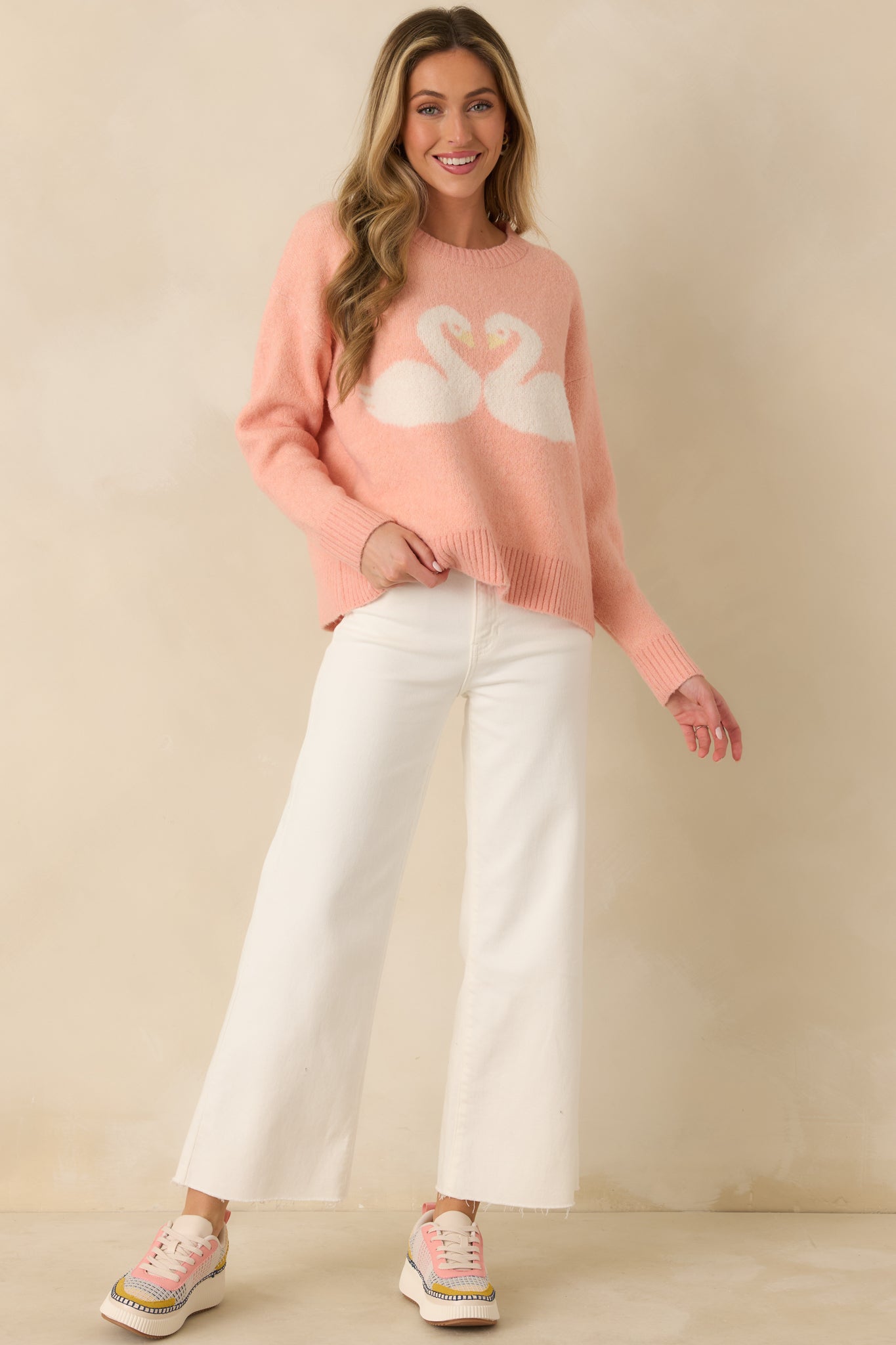 Coral knit sweater with a relaxed silhouette, classic crew neckline, and long sleeves, finished with ribbed trim at the neckline, cuffs, and hem.