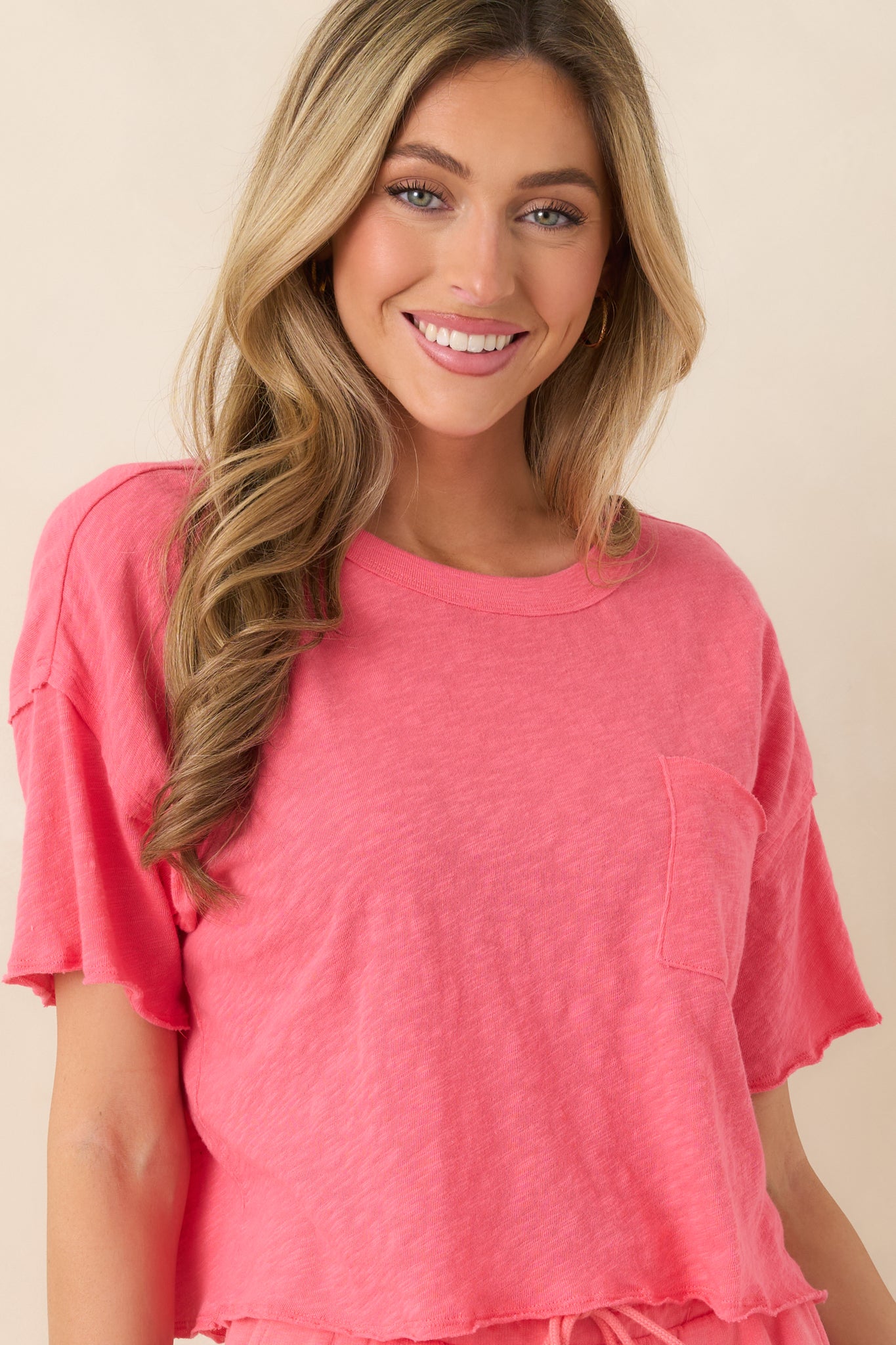 Coral pink tee showing slightly cropped length and soft drape.