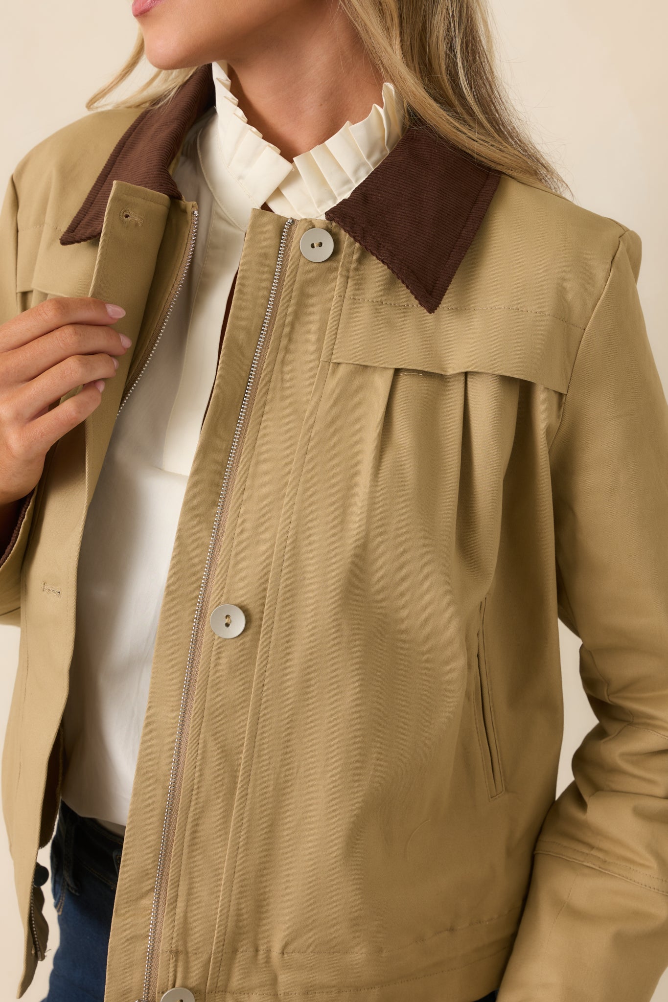 Detailed view of the brown corduroy collar, pleated construction, hidden zipper, and three-button front closure.