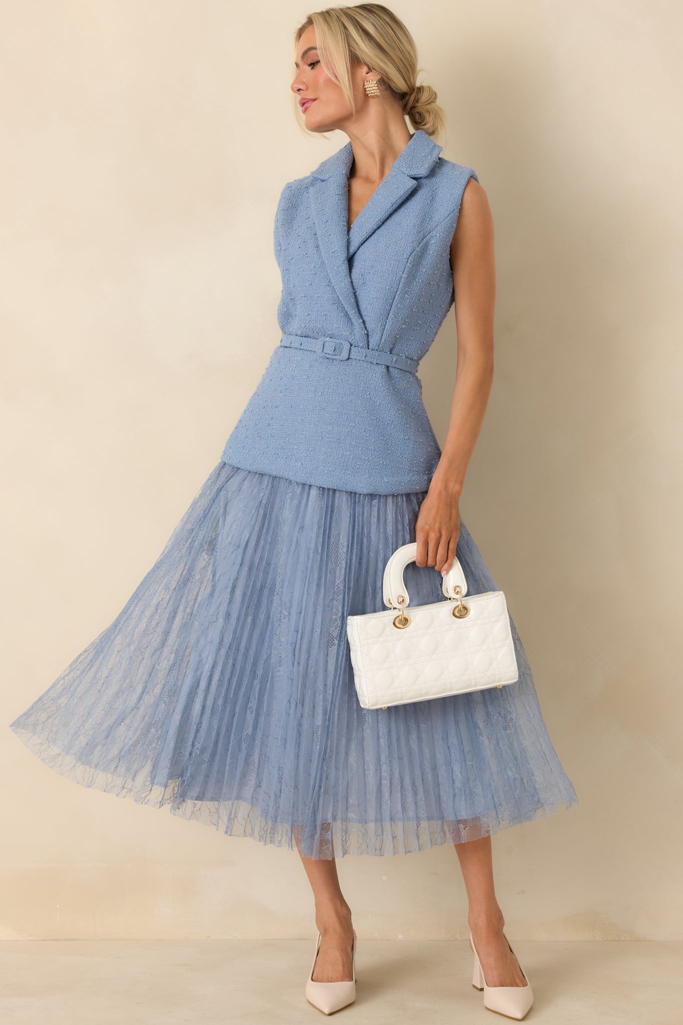 Cornflower blue midi dress with a sleeveless tweed-inspired bodice, wrap-style front, and flowing pleated lace skirt.