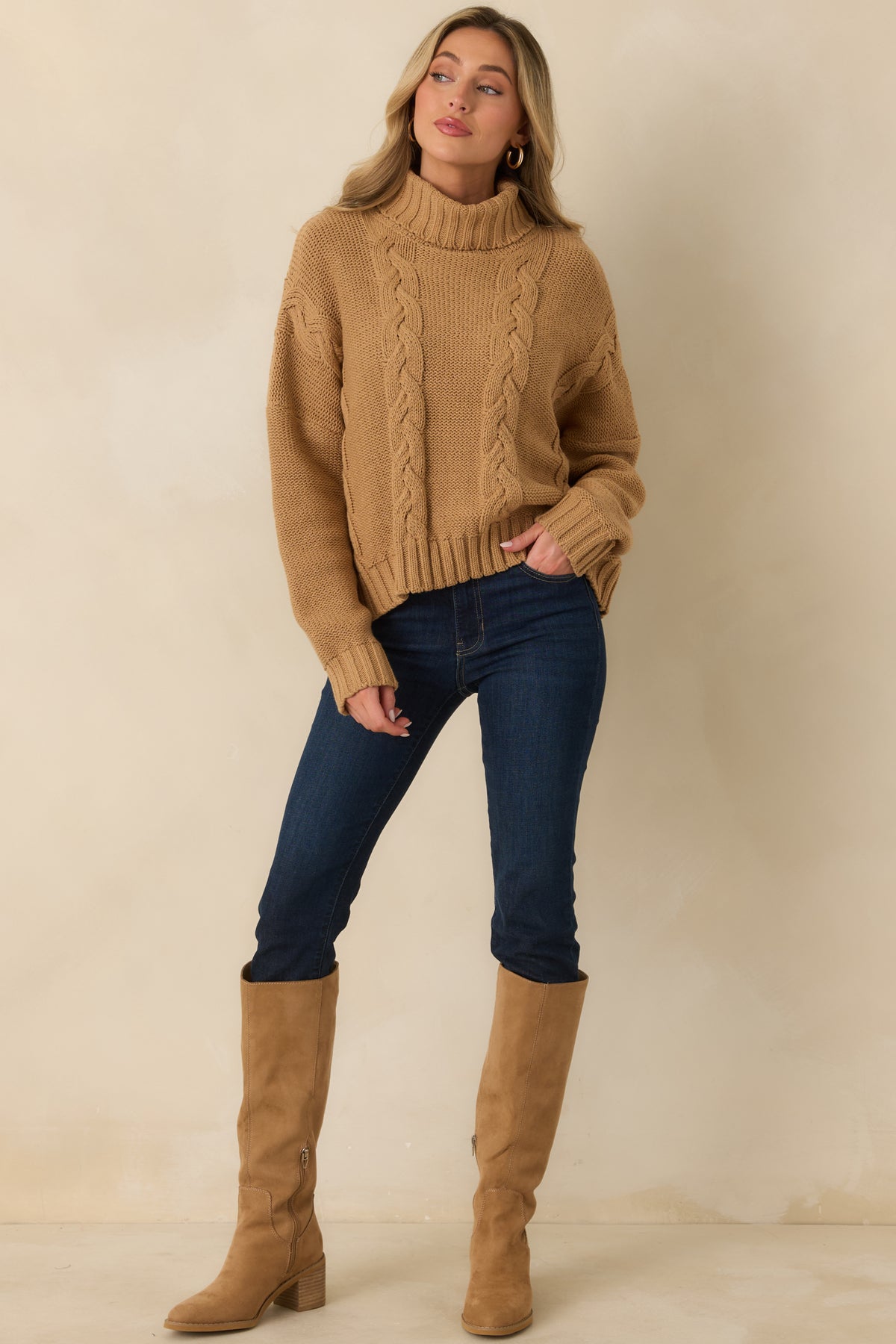 Cotton-blend sweater showcasing a chunky cable design, relaxed long sleeves, ribbed cuffs, and a coordinating hem.