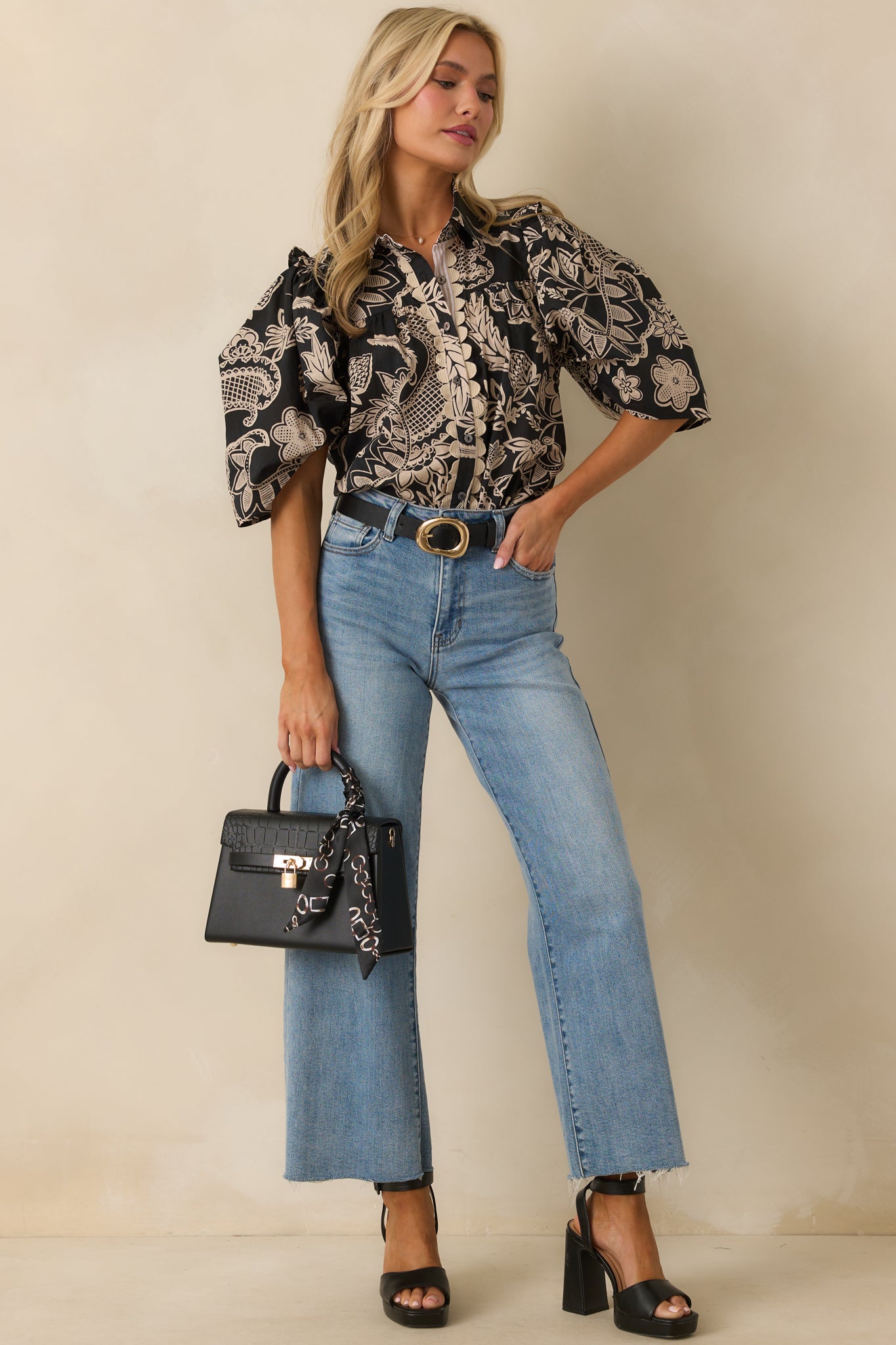 Relaxed-fit cotton blouse with beige and black floral pattern, ruffle accents, and button-front closure.