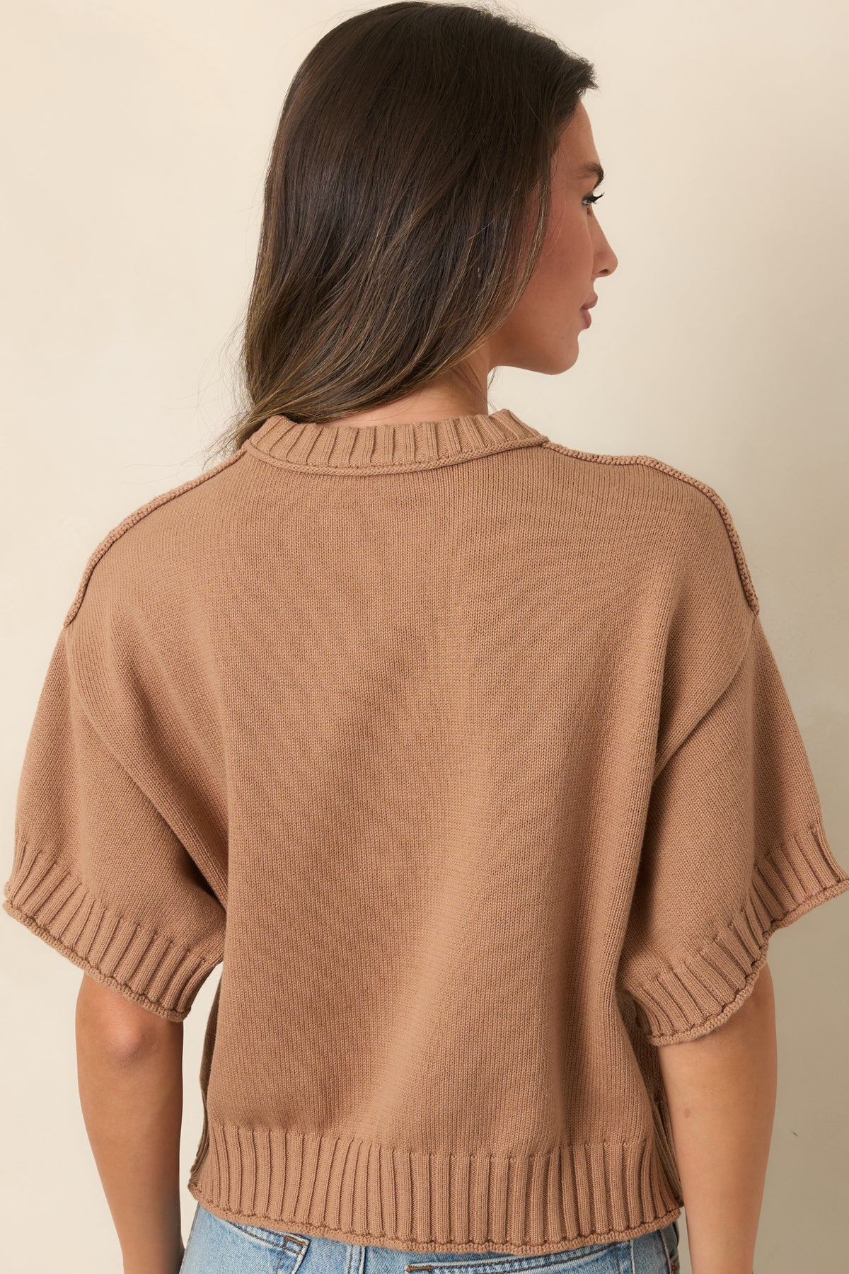 Rear view of the 100% cotton top showing the slightly boxy silhouette, short sleeves, and ribbed hem.
