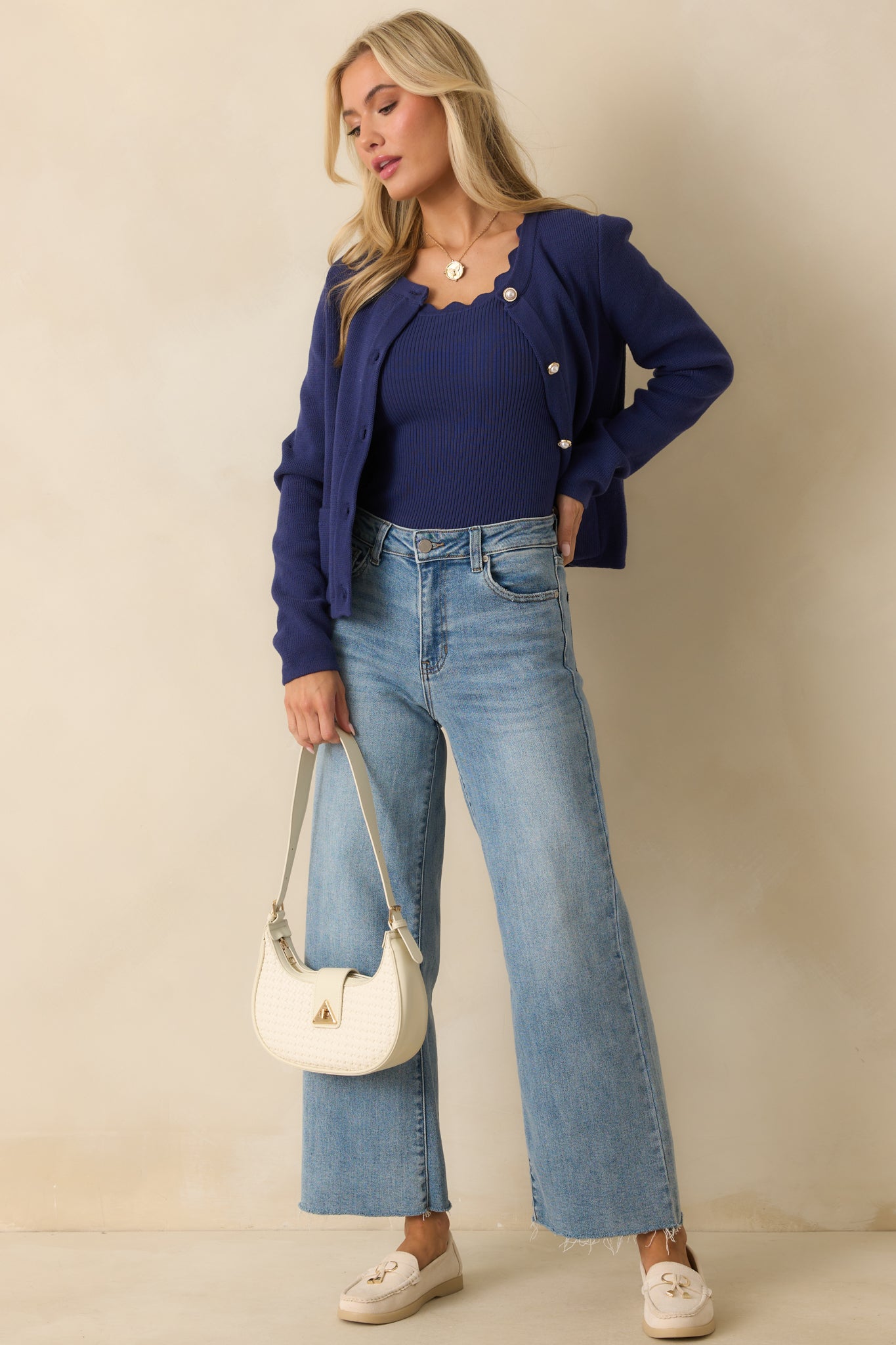 Cotton knit cardigan highlighting the front patch pockets, long sleeves, and polished gold-tone button accents.
