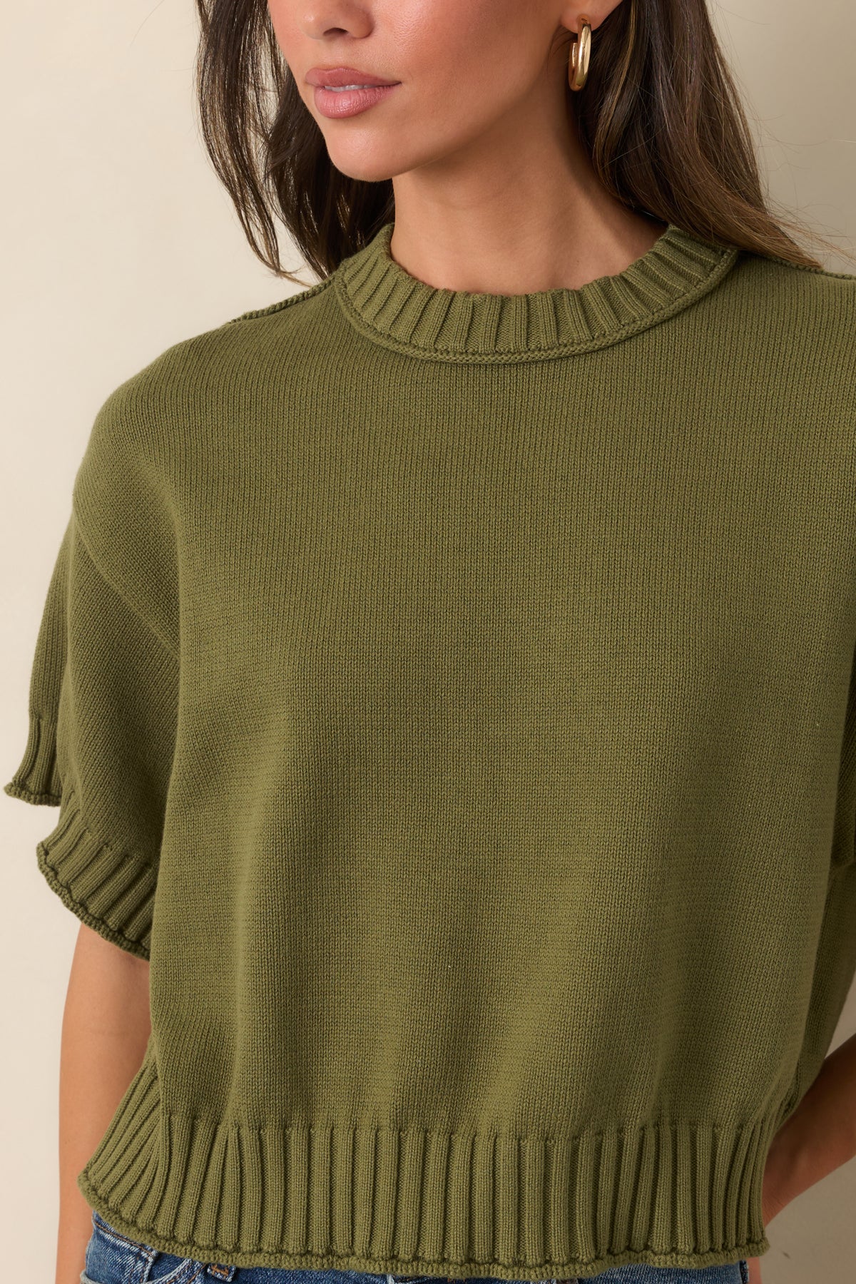 Close-up of the cotton fabric and chunky ribbed trim at the neckline and sleeve cuffs.
