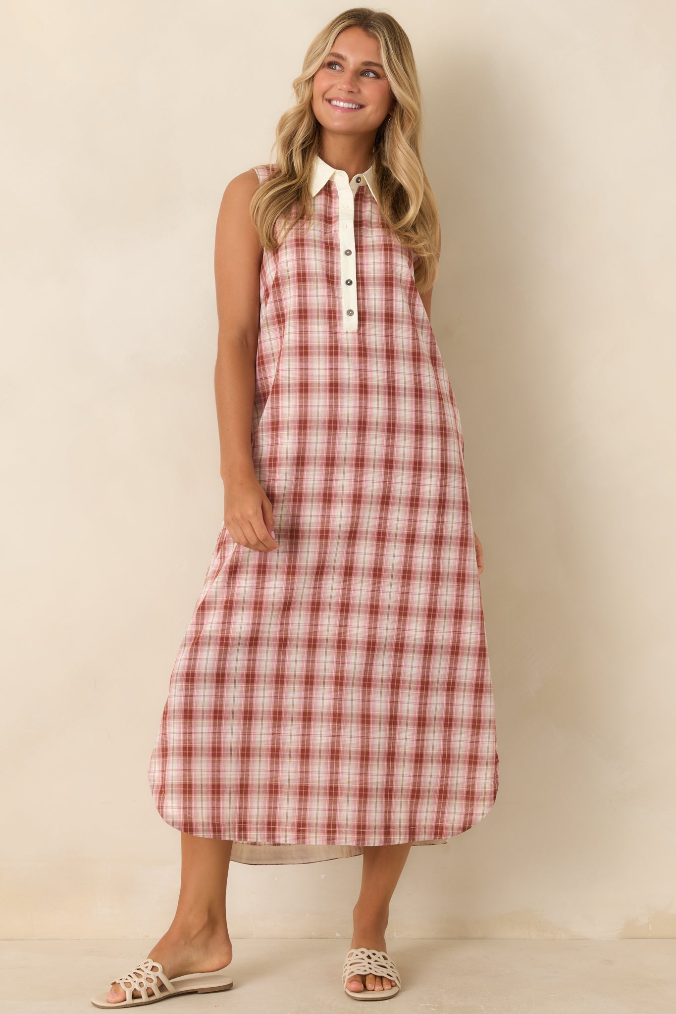 Cotton sleeveless dress featuring a crisp collared neckline, partial button-front placket, ivory trim, and side pockets.