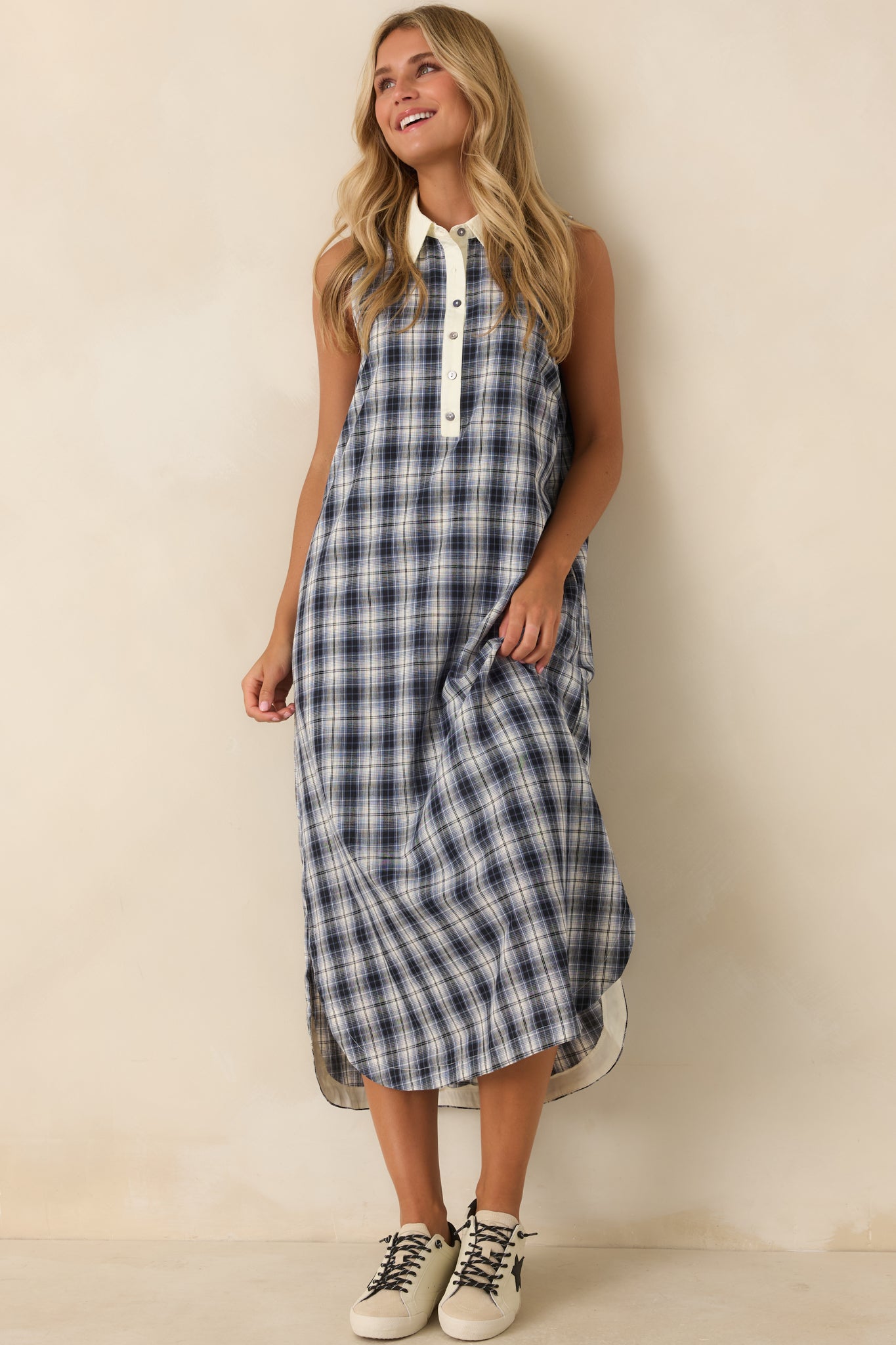 Cotton sleeveless dress featuring a crisp collared neckline, partial button-front placket, ivory trim, and side pockets.