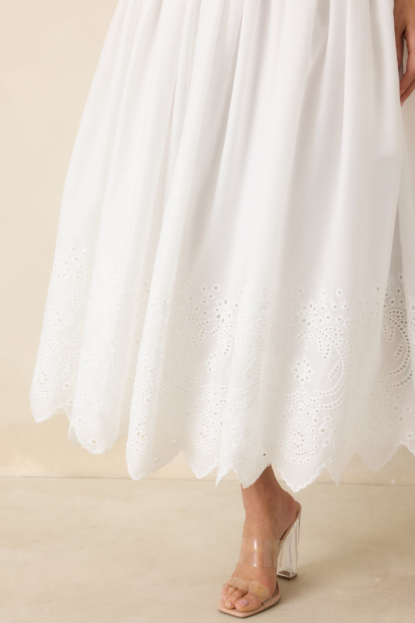 Cotton eyelet skirt detail with scalloped hem and textured cutout pattern.