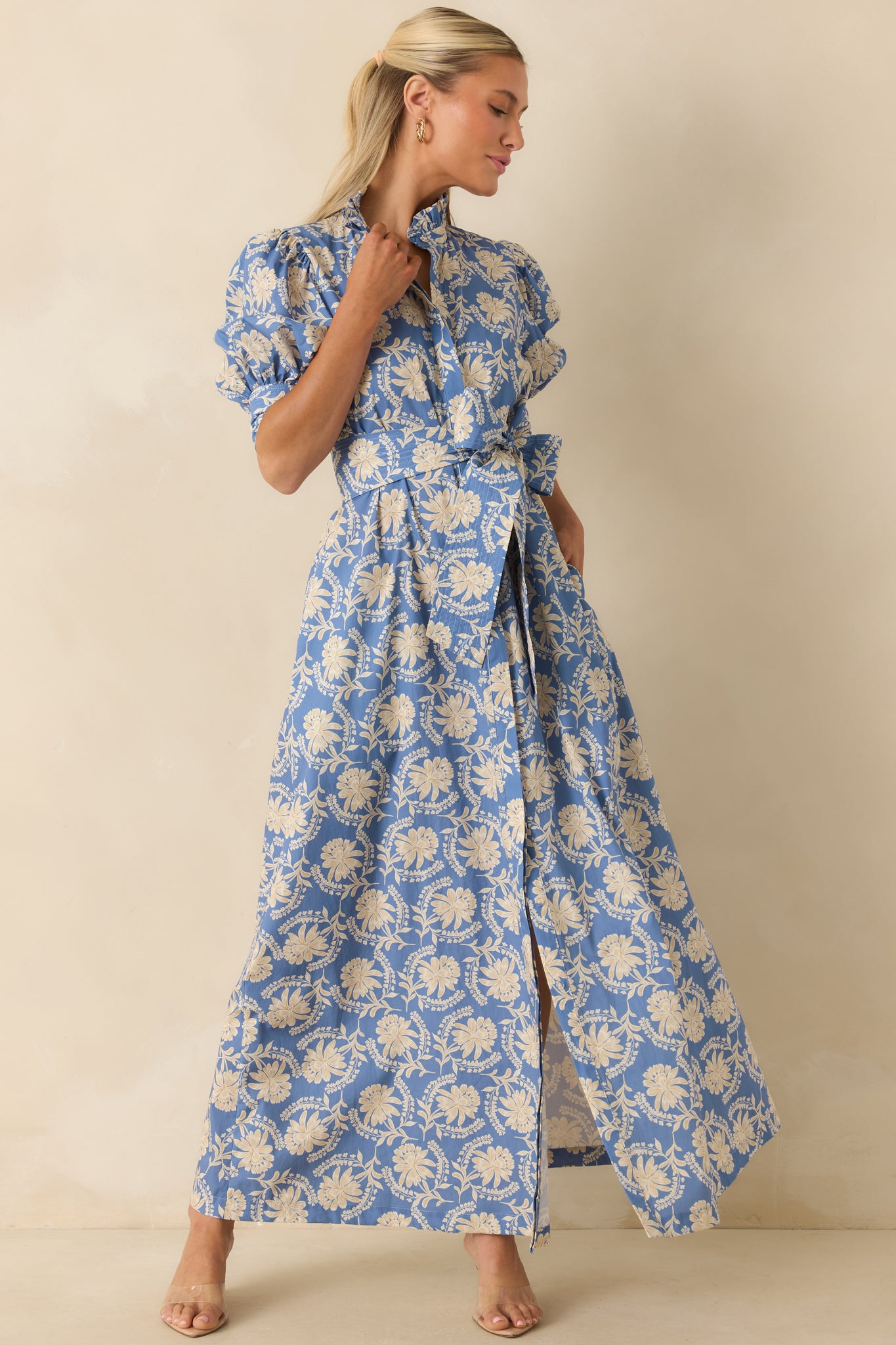 Cotton maxi dress with a dusty blue and ivory floral print, smocked cuff puff sleeves, hidden side pockets, and a flowing full-length skirt.