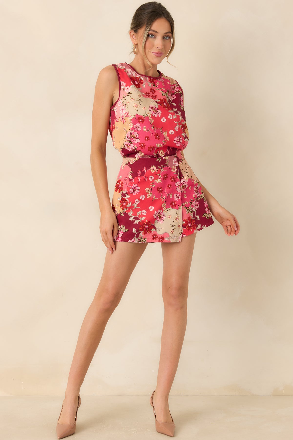 Cotton floral top with scattered multicolor blossoms, leafy green accents, and burgundy edging around the neckline and armholes.