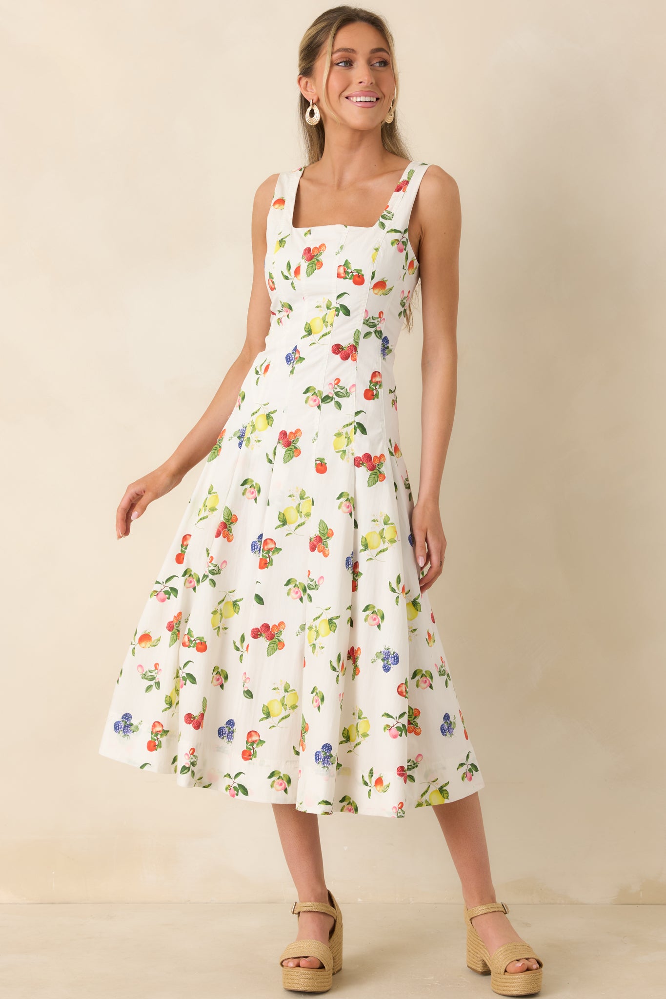 Cotton fruit print dress with tailored bodice, pleated skirt, and flattering midi length